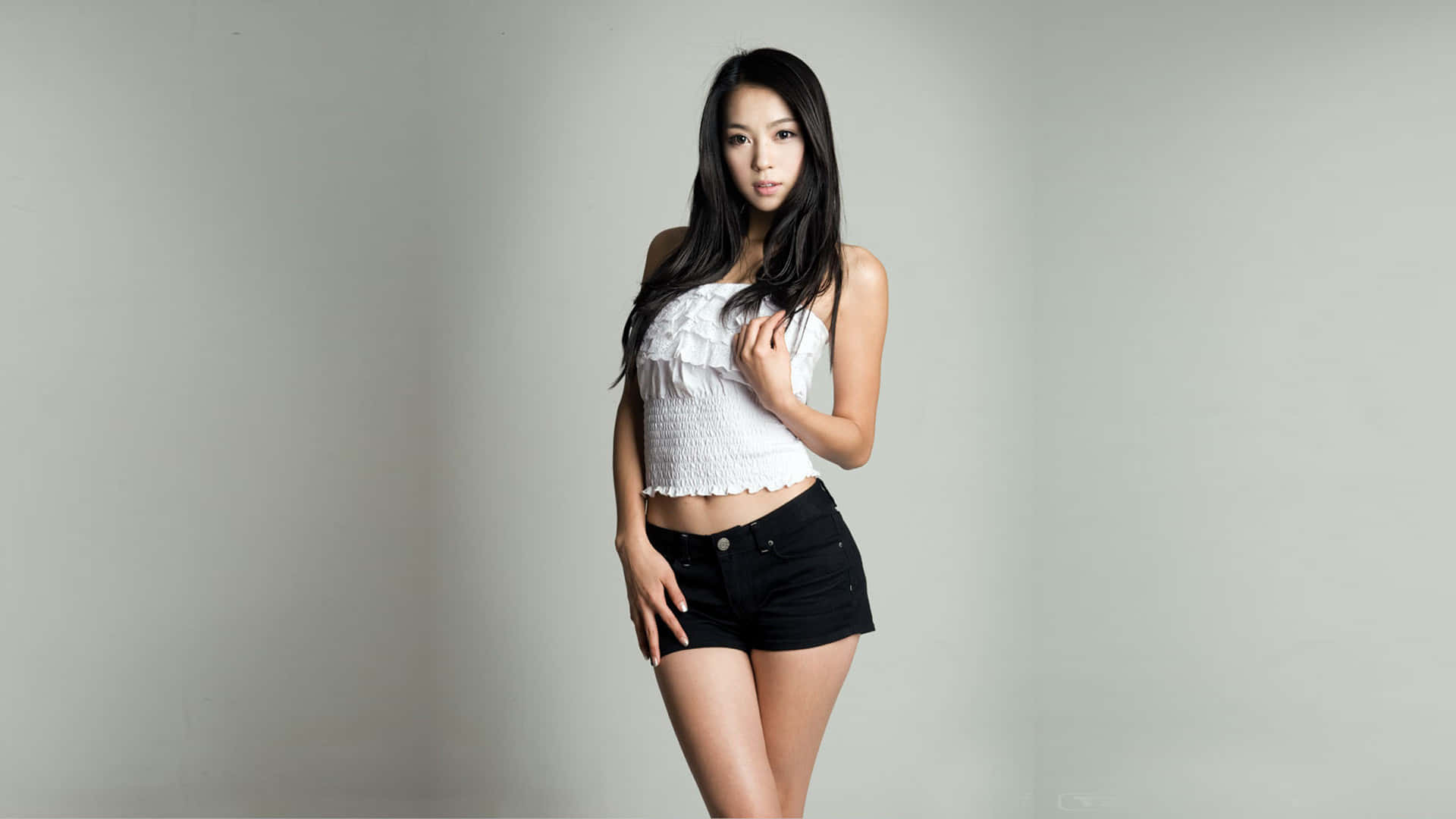 Sød koreansk pige iført en hvid rynket rørtop. Wallpaper