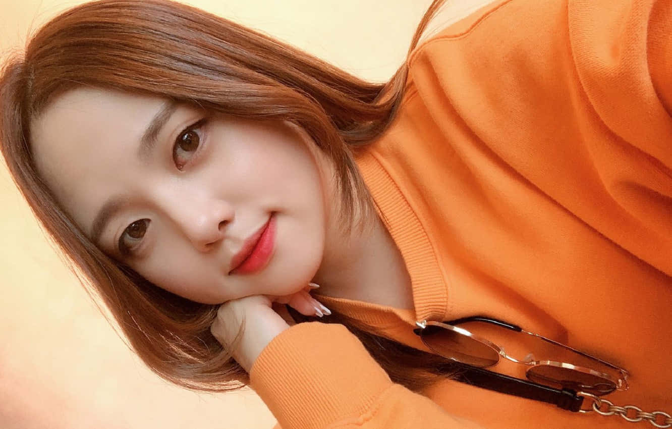 Sötkoreansk Tjej Med Orange Skjorta Som Bär. Wallpaper