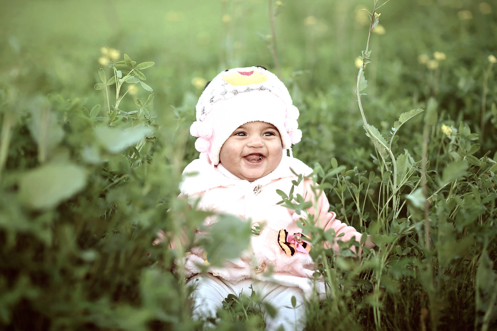 Sød latter Baby på vild græs baggrund Wallpaper