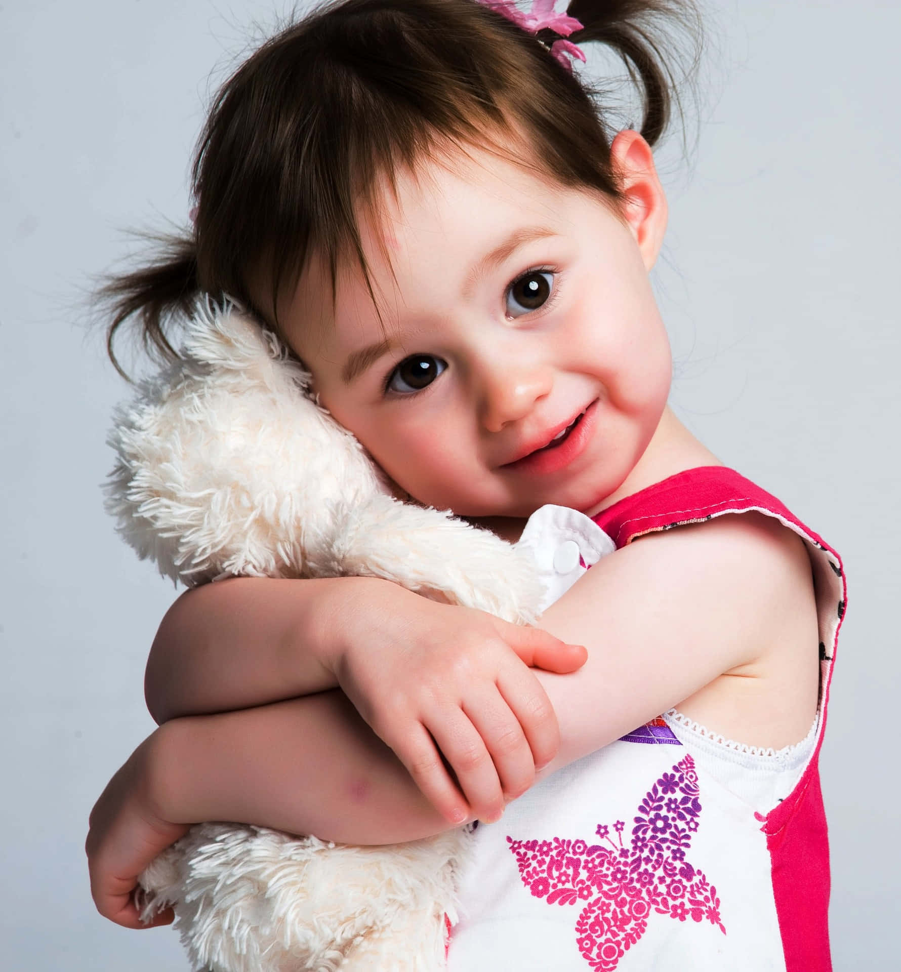 Cute Photo Of A Young Girl Hugging Her Tangible White Stuffed Toy Wallpaper