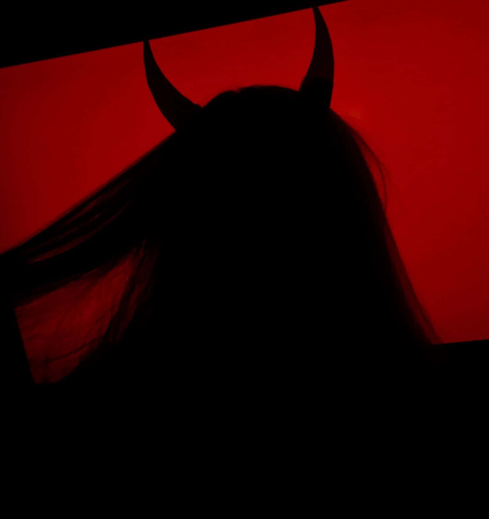 En kvindes hoved er silhouetterede mod et rødt baggrund Wallpaper