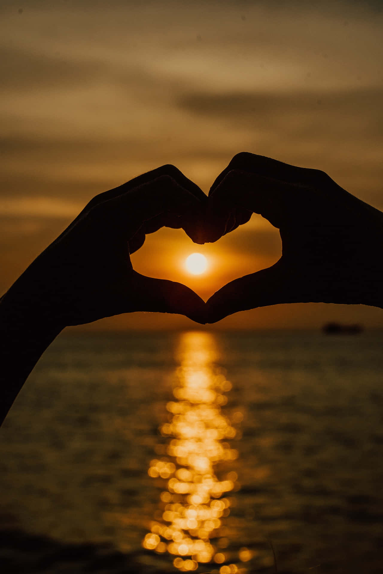 Two Hands Making A Heart Shape At Sunset Wallpaper