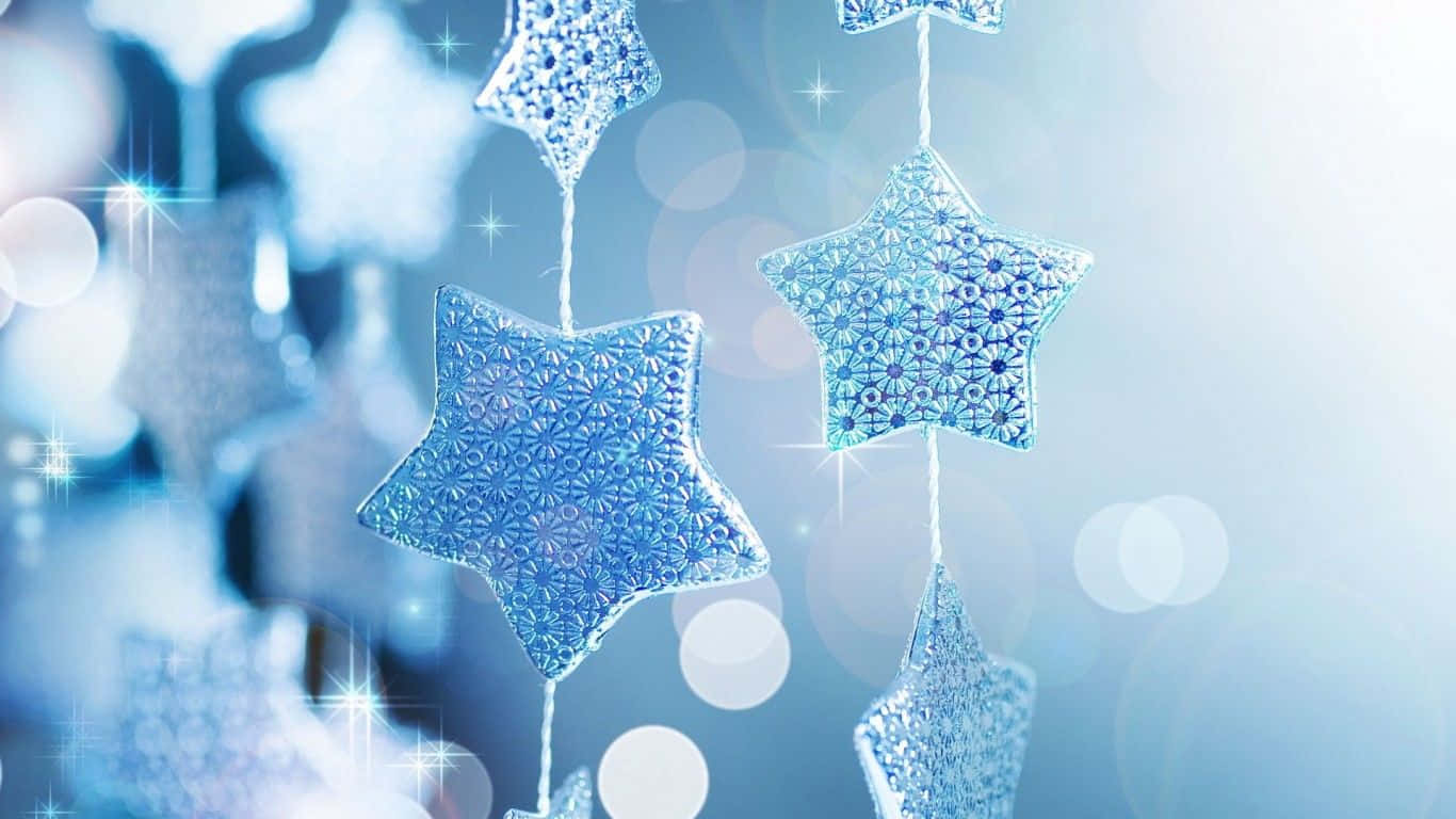 Decoraçõesde Estrelas De Natal Penduradas Em Um Fundo Azul. Papel de Parede