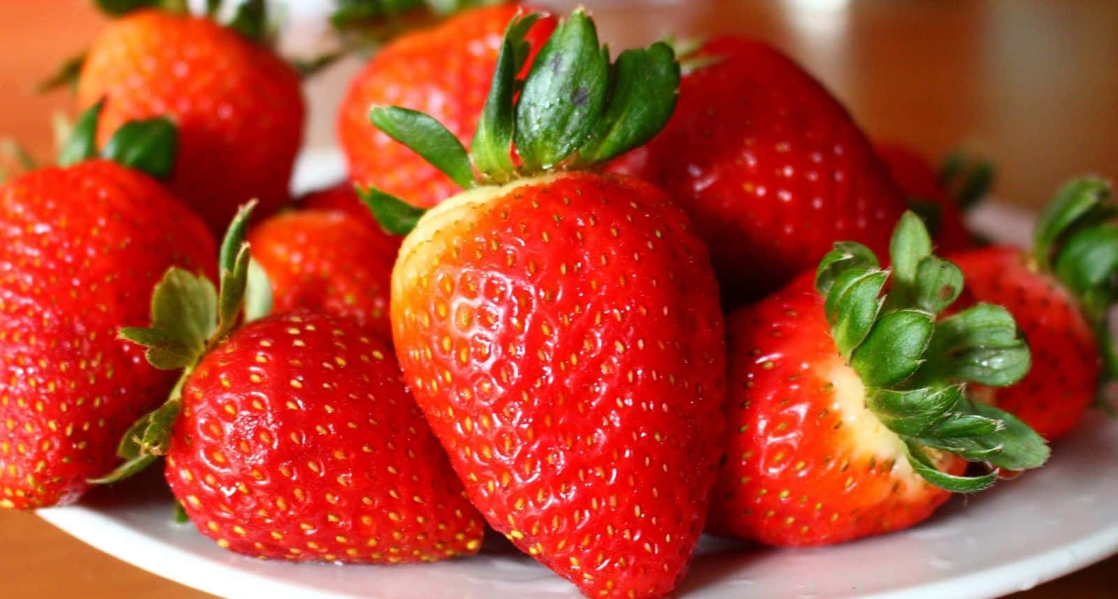 A Plate Of Strawberries On A Table Wallpaper