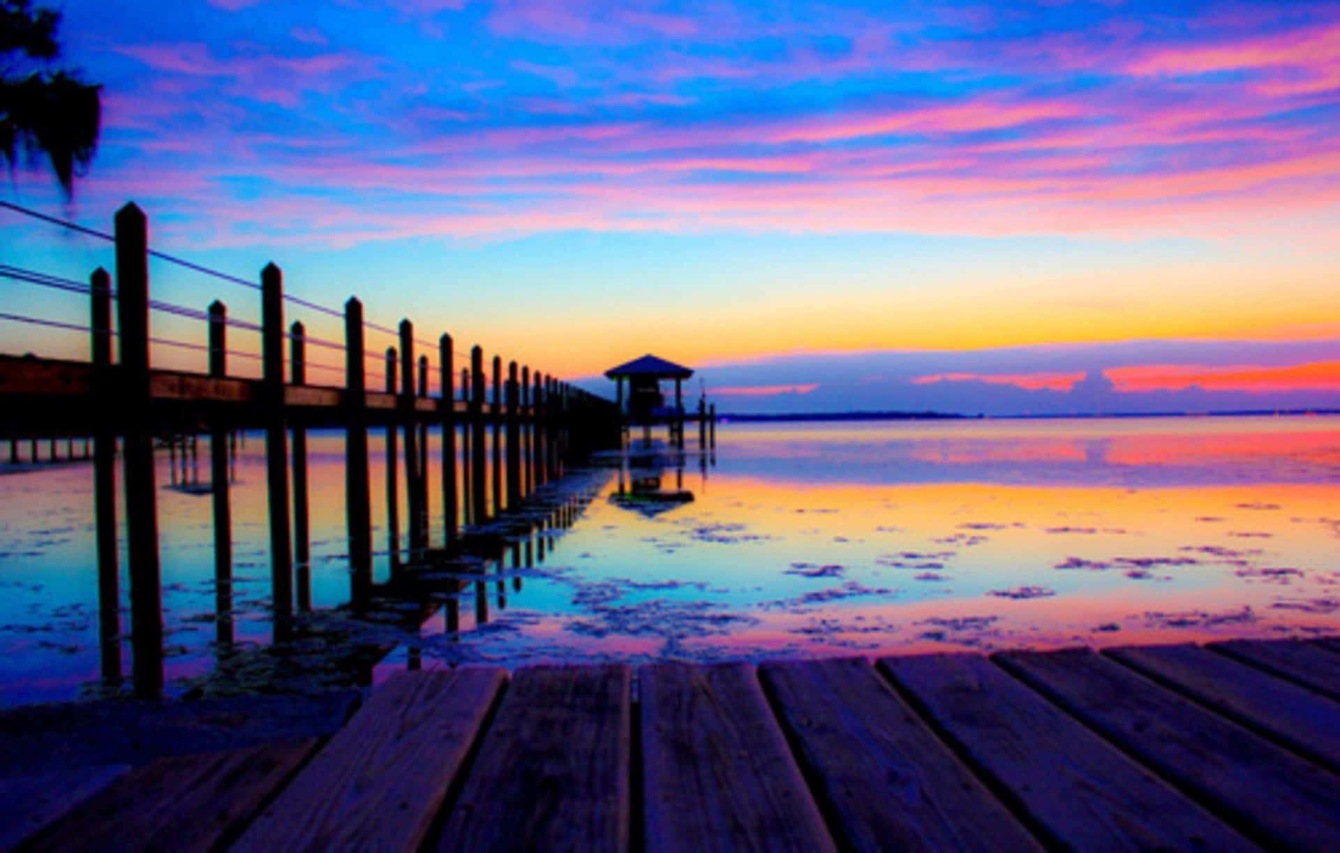 A Dock With A Colorful Sunset Wallpaper
