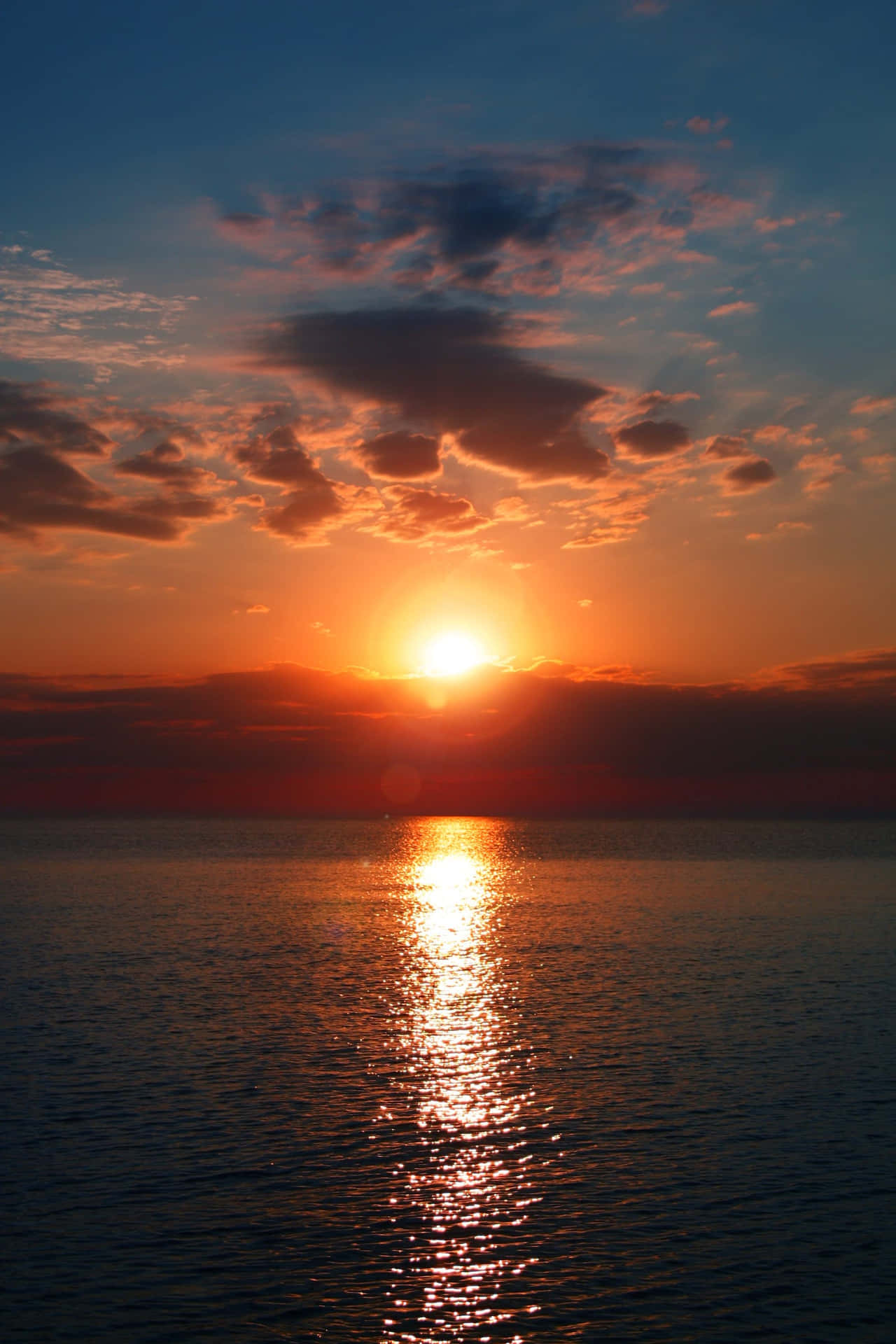 A beautiful, serene sunset over a distant horizon. Wallpaper