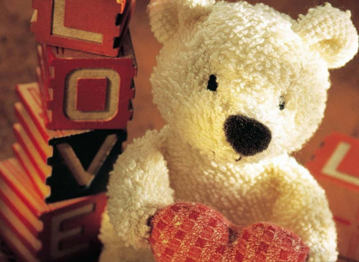 A Teddy Bear Holding A Heart Shaped Block