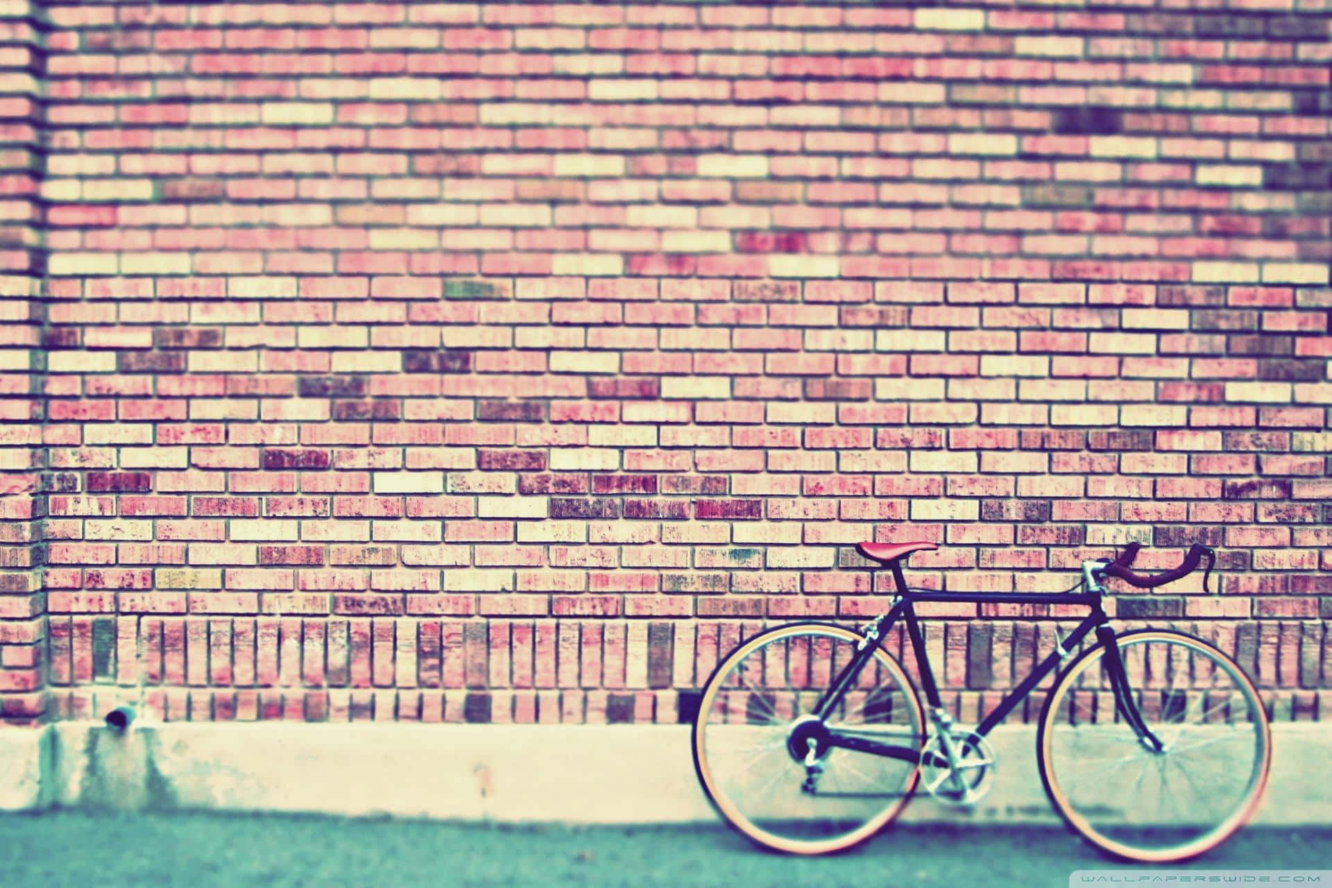 En cykel parkeret mod en mursten væg Wallpaper