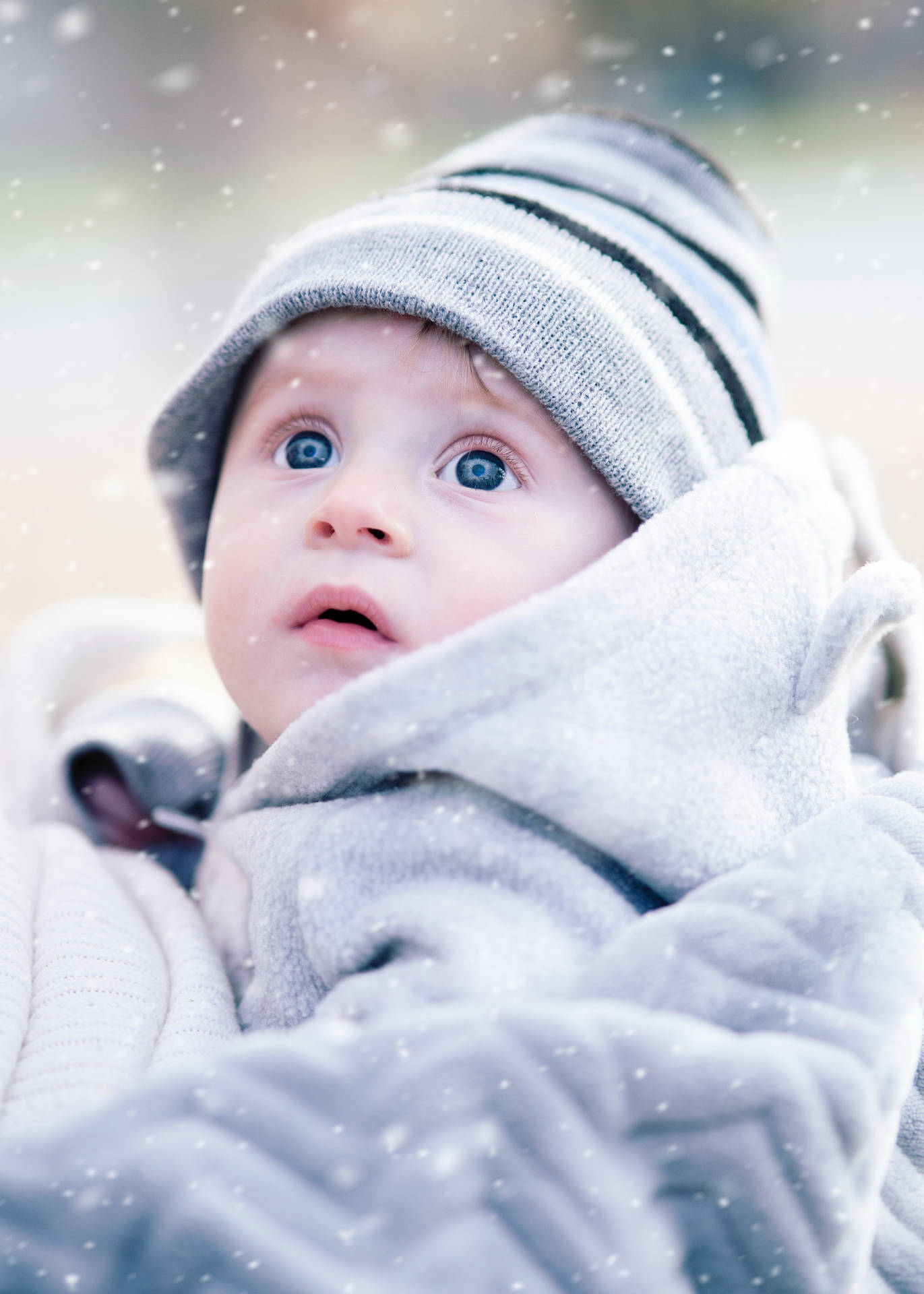 Cute Winter Baby Admiring Falling Snow Wallpaper
