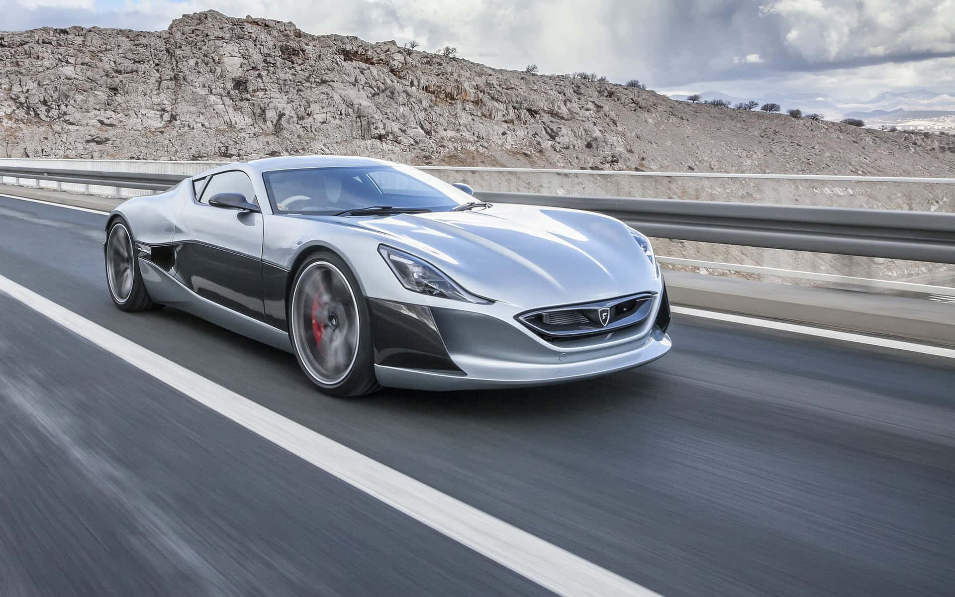 Cutting-edge Rimac Concept One Electric Supercar Against A Stormy Sky Backdrop Wallpaper