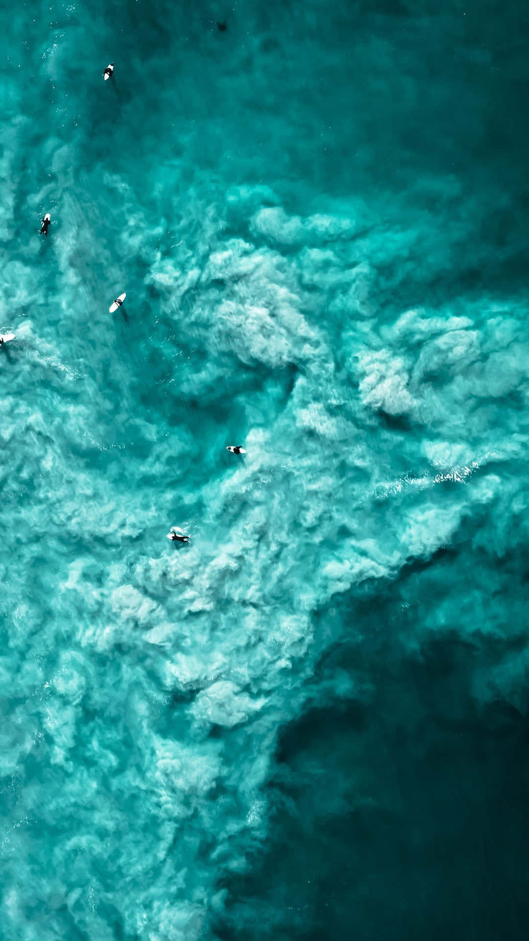 En gruppe surfere i havet rider bølgerne. Wallpaper