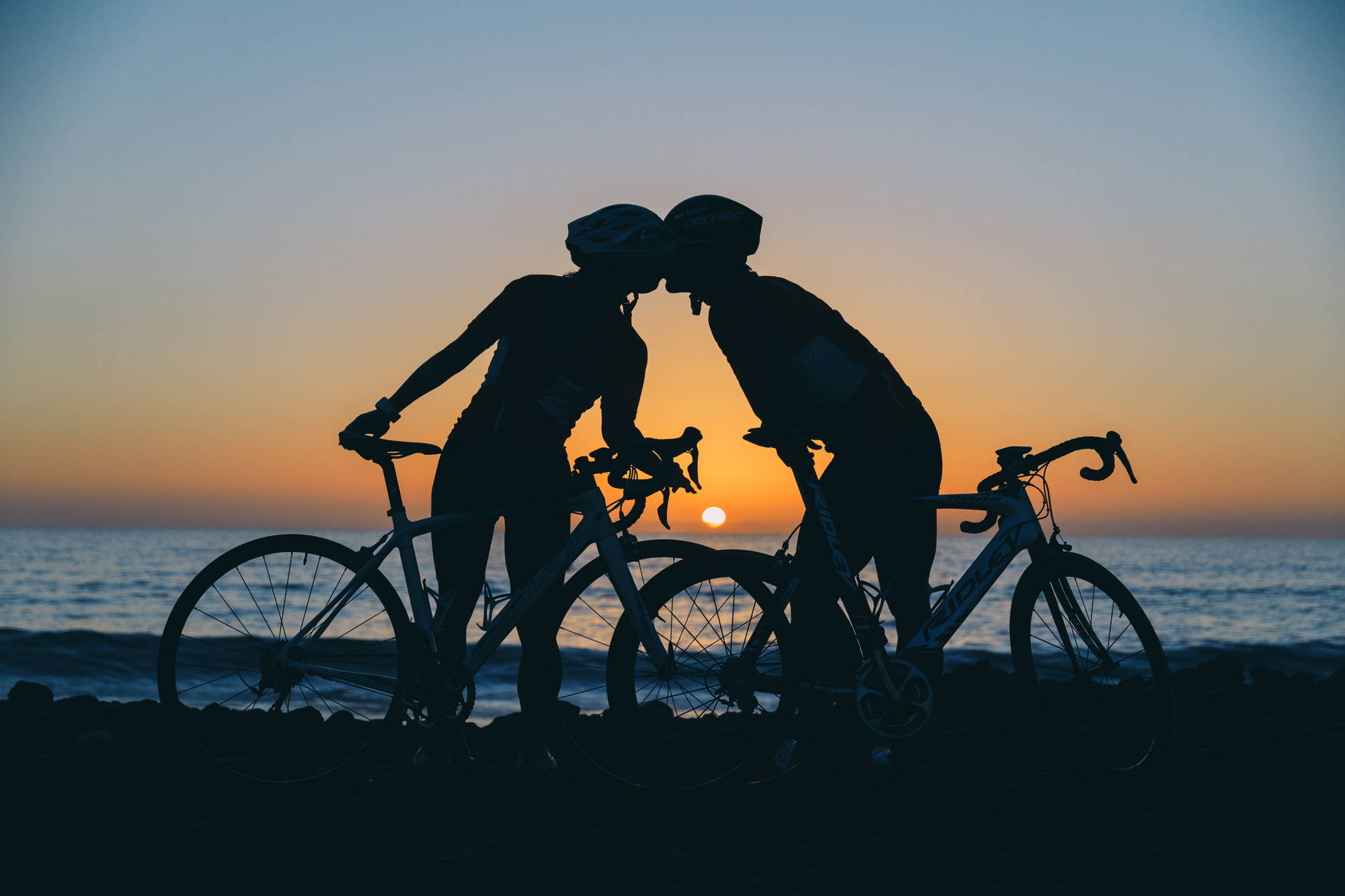 Casalde Ciclistas Em Silhueta Durante O Pôr Do Sol Papel de Parede
