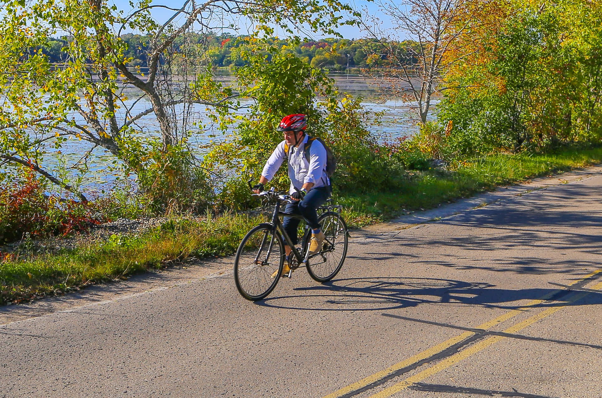 Cyclist Enjoying Autumn Ride By The Lake Wallpaper