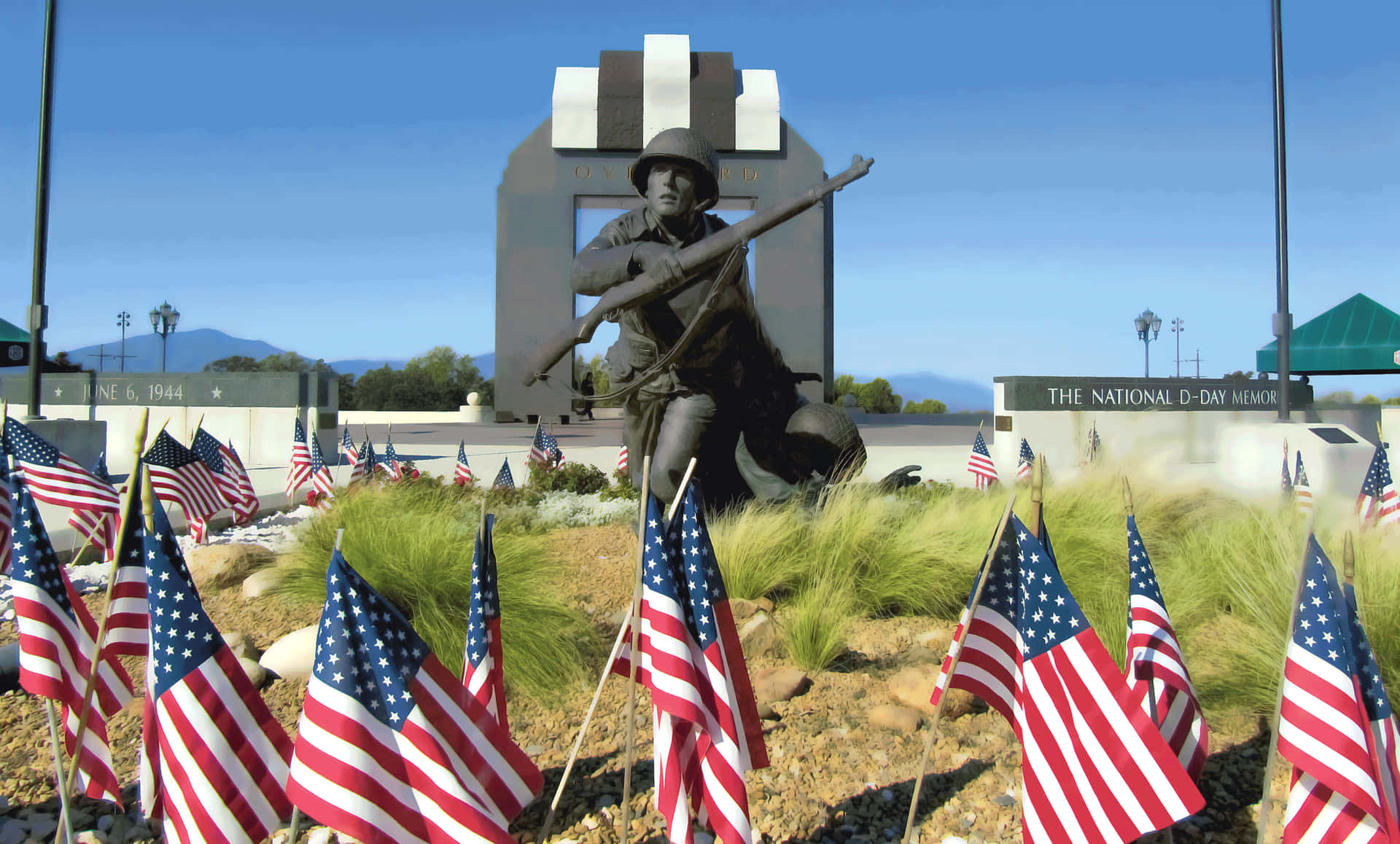 A Statue Of A Soldier With American Flags In Front Of Him