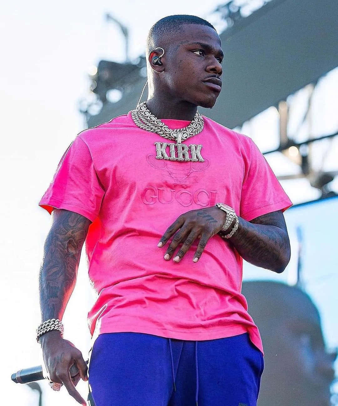 DaBaby performs energetically on stage in front of an excited crowd.
