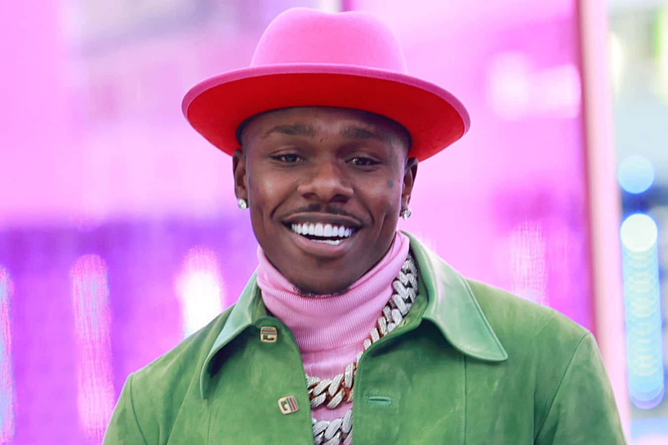 DaBaby in a stylish pose against a graffiti backdrop