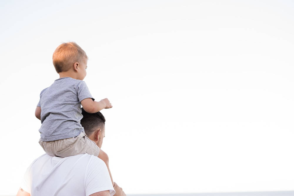 Dad Carrying Son On His Shoulders Wallpaper