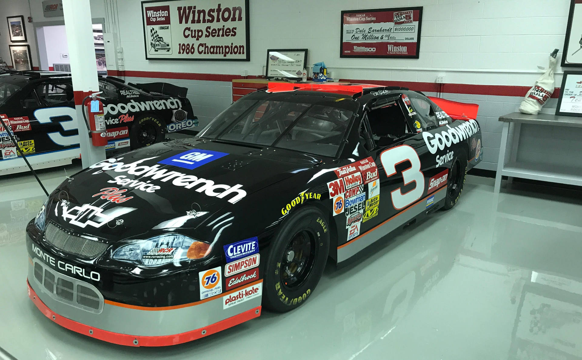 En NASCAR-bil er parkeret i et garage Wallpaper