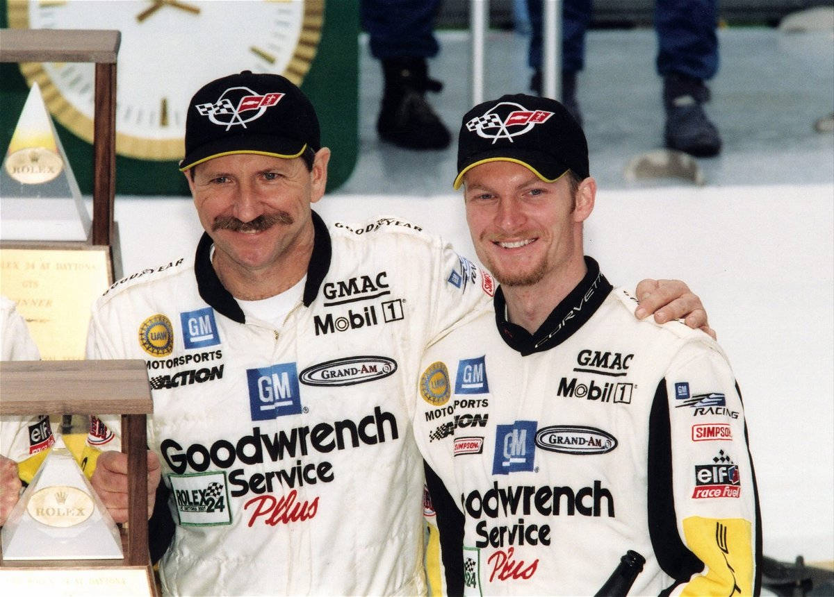 Two Men In Nascar Uniforms Standing Next To Each Other Wallpaper