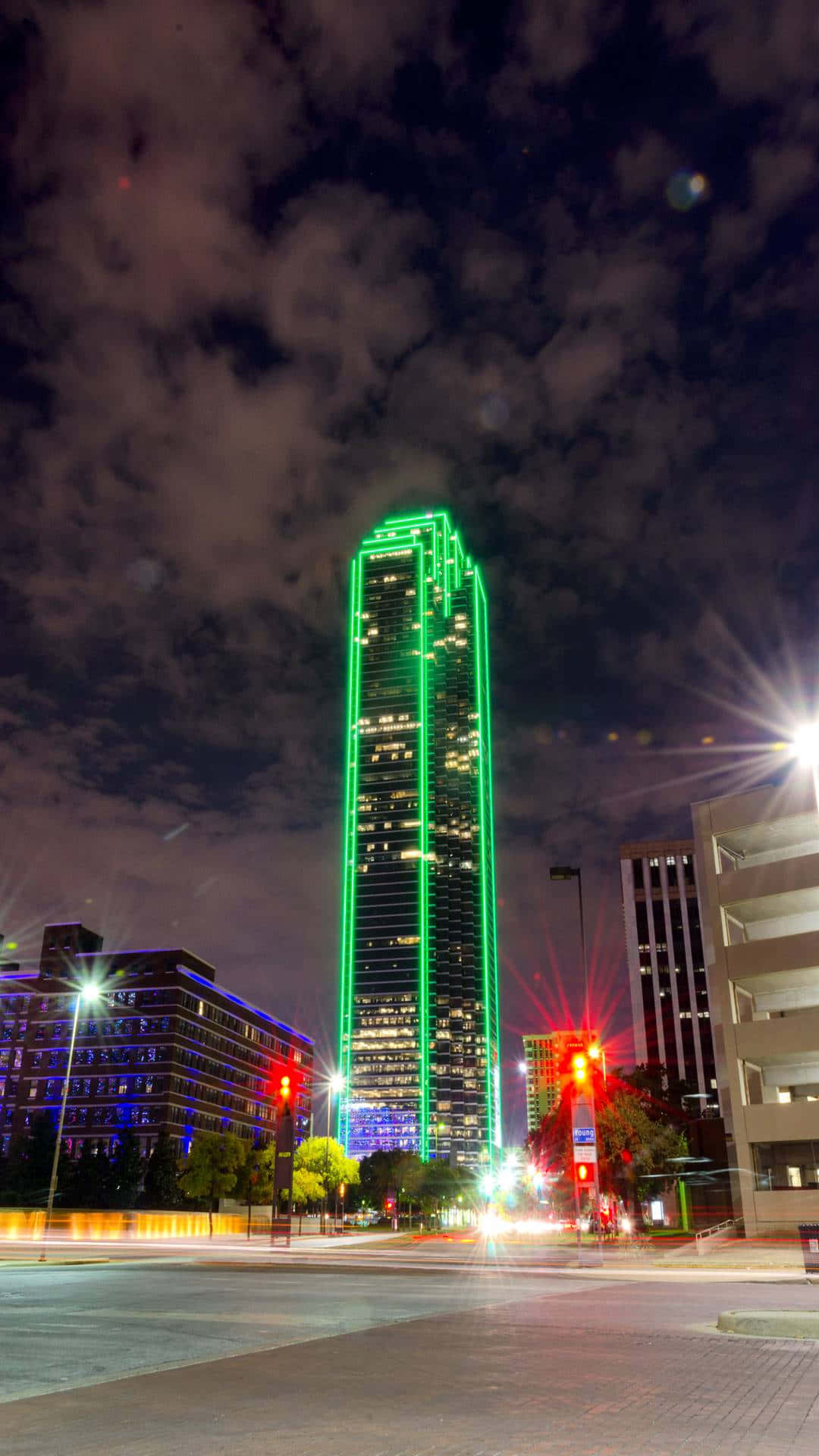 Et højt bygning med grønne lamper på toppen Wallpaper