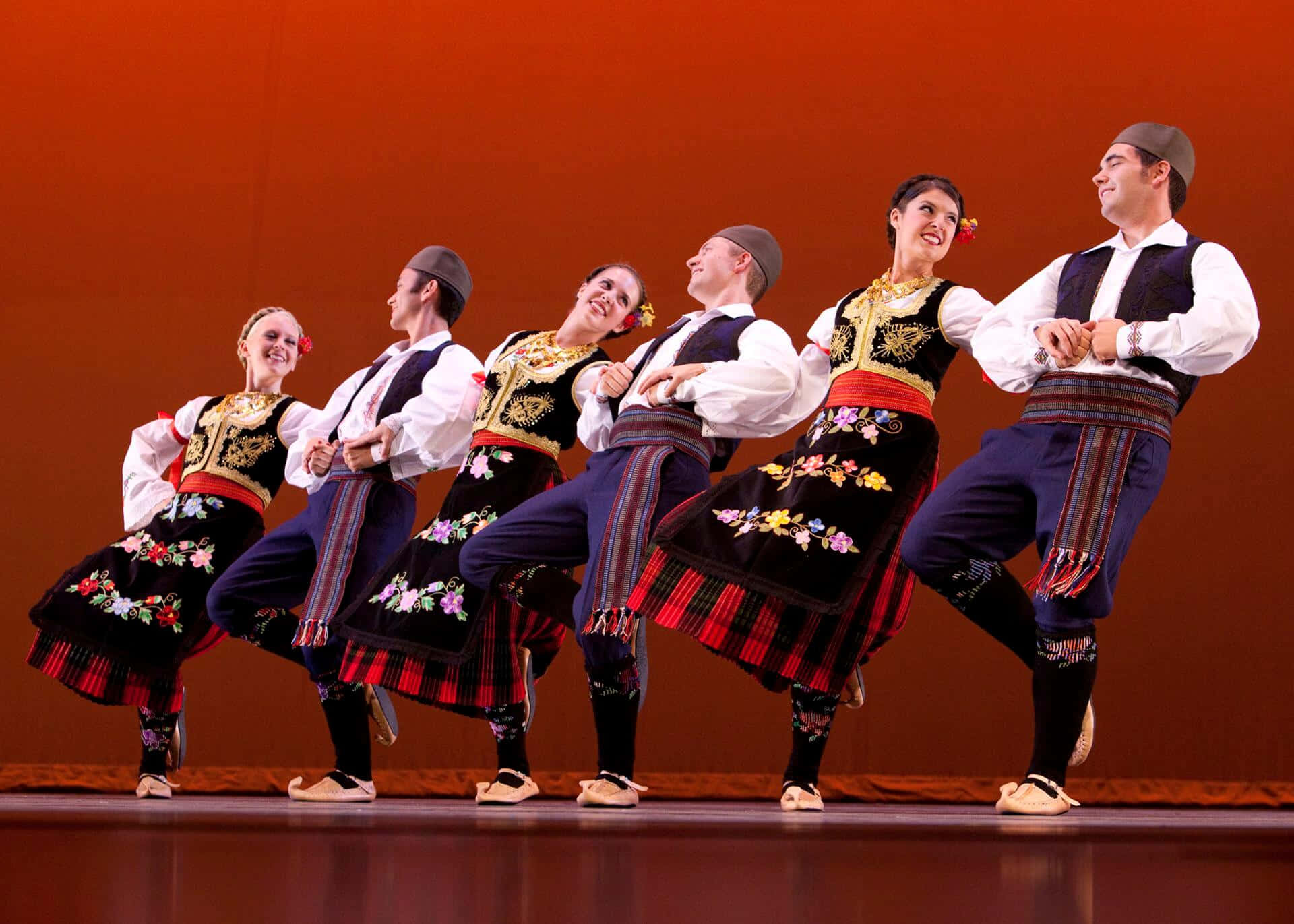 Einegruppe Von Menschen In Traditionellen Kostümen Tanzt.