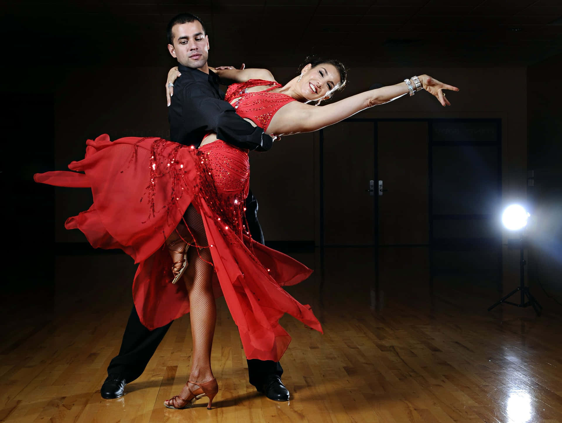 A Couple In Red Dancing In A Dark Room