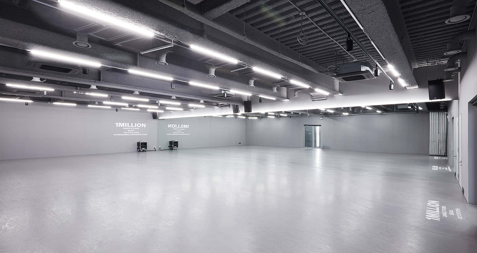 A Large Empty Room With White Walls And Lights