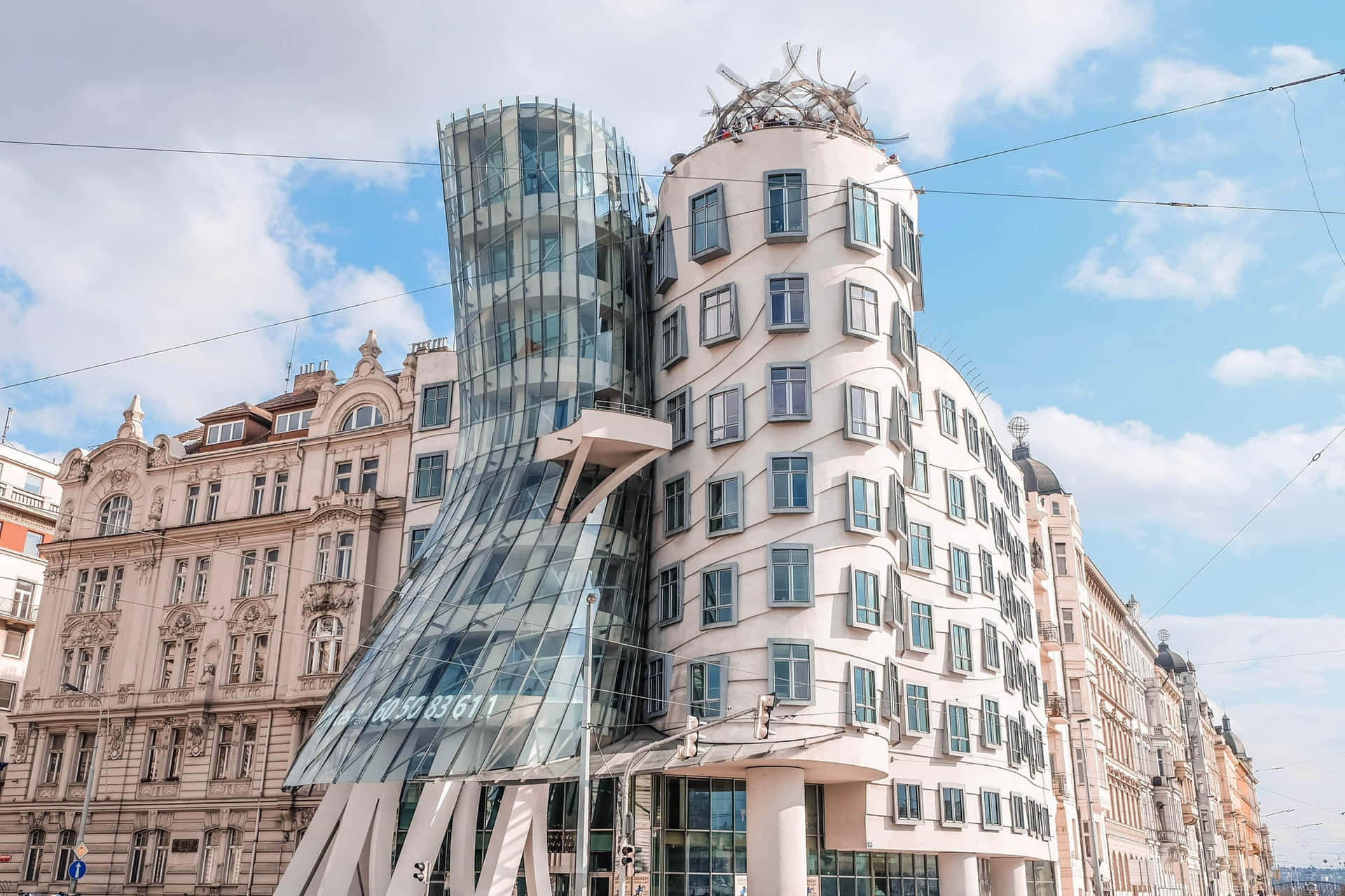 Enchanting View of the Dancing House in Prague under the Cloudy Blue Sky Wallpaper