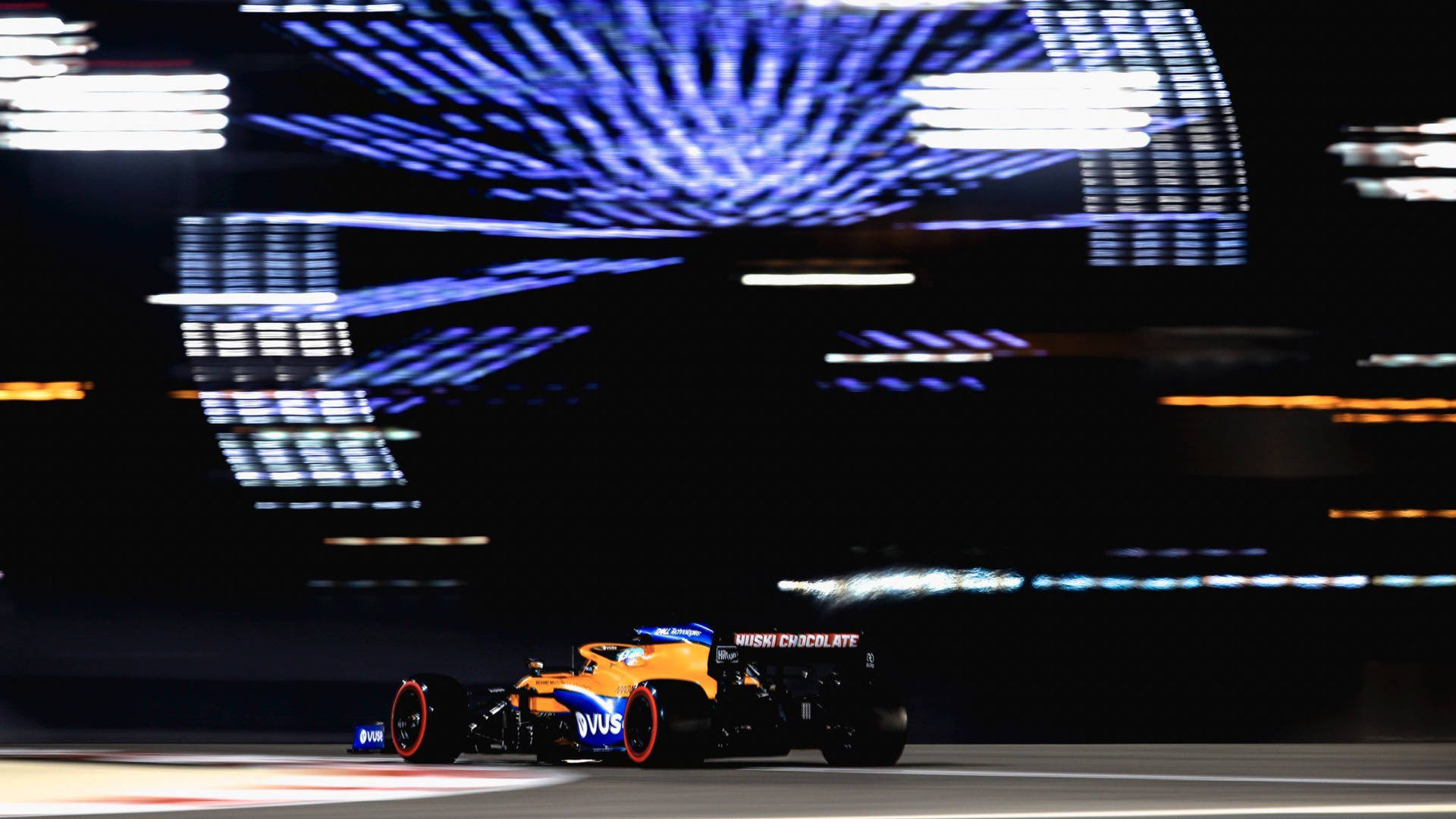 Daniel Ricciardo F1 Car Against Billboard Screen Wallpaper