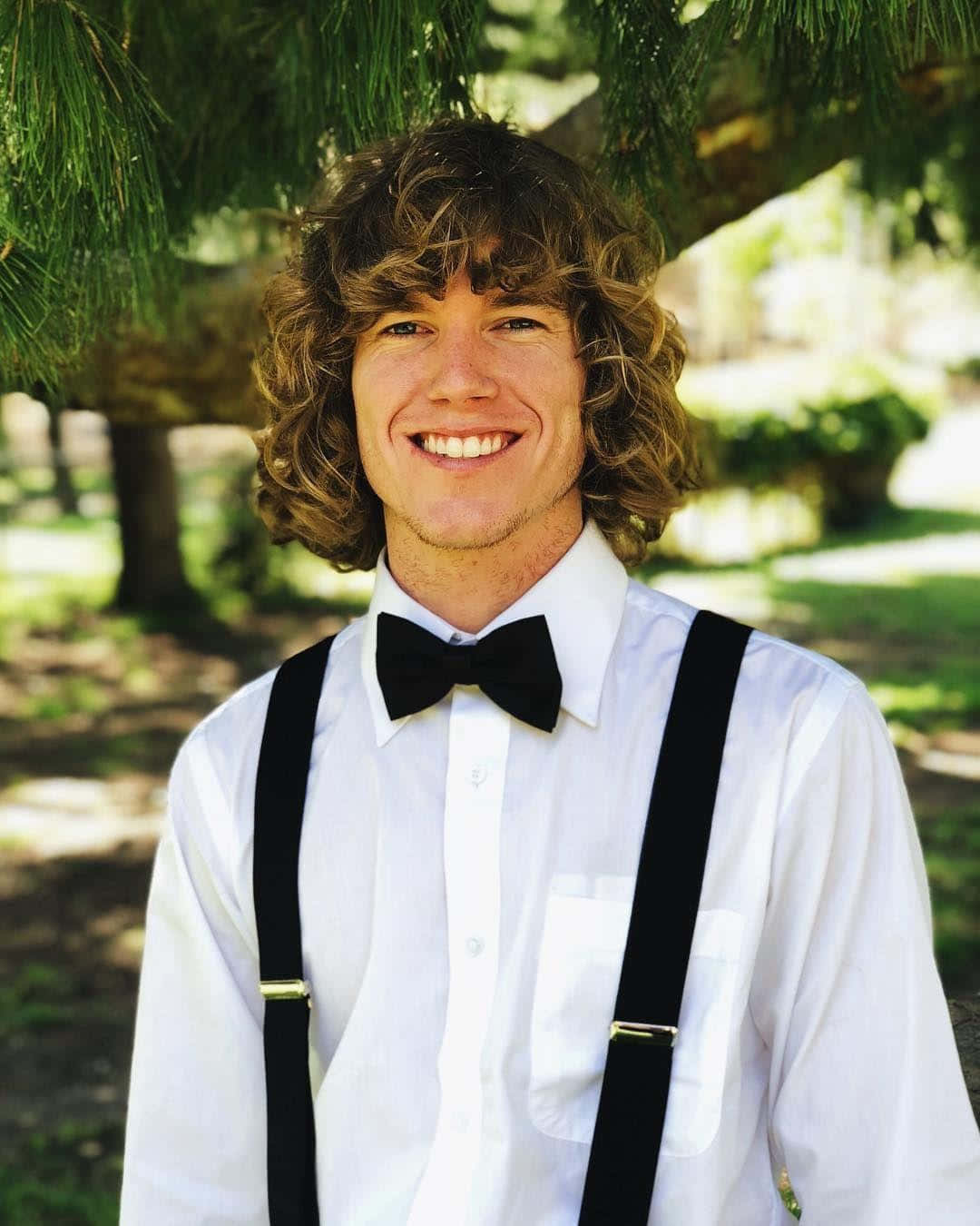 A Young Man Wearing Suspenders And A Bow Tie Wallpaper