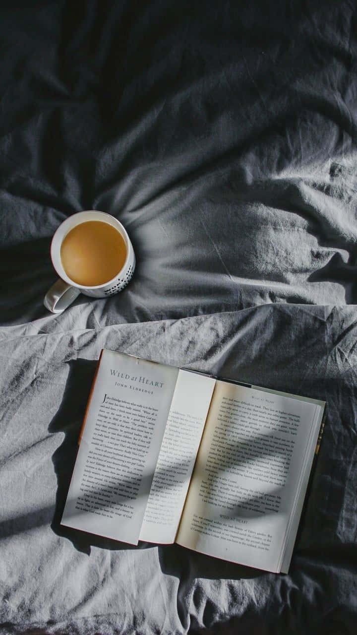 En bog og en kop te på et natbord