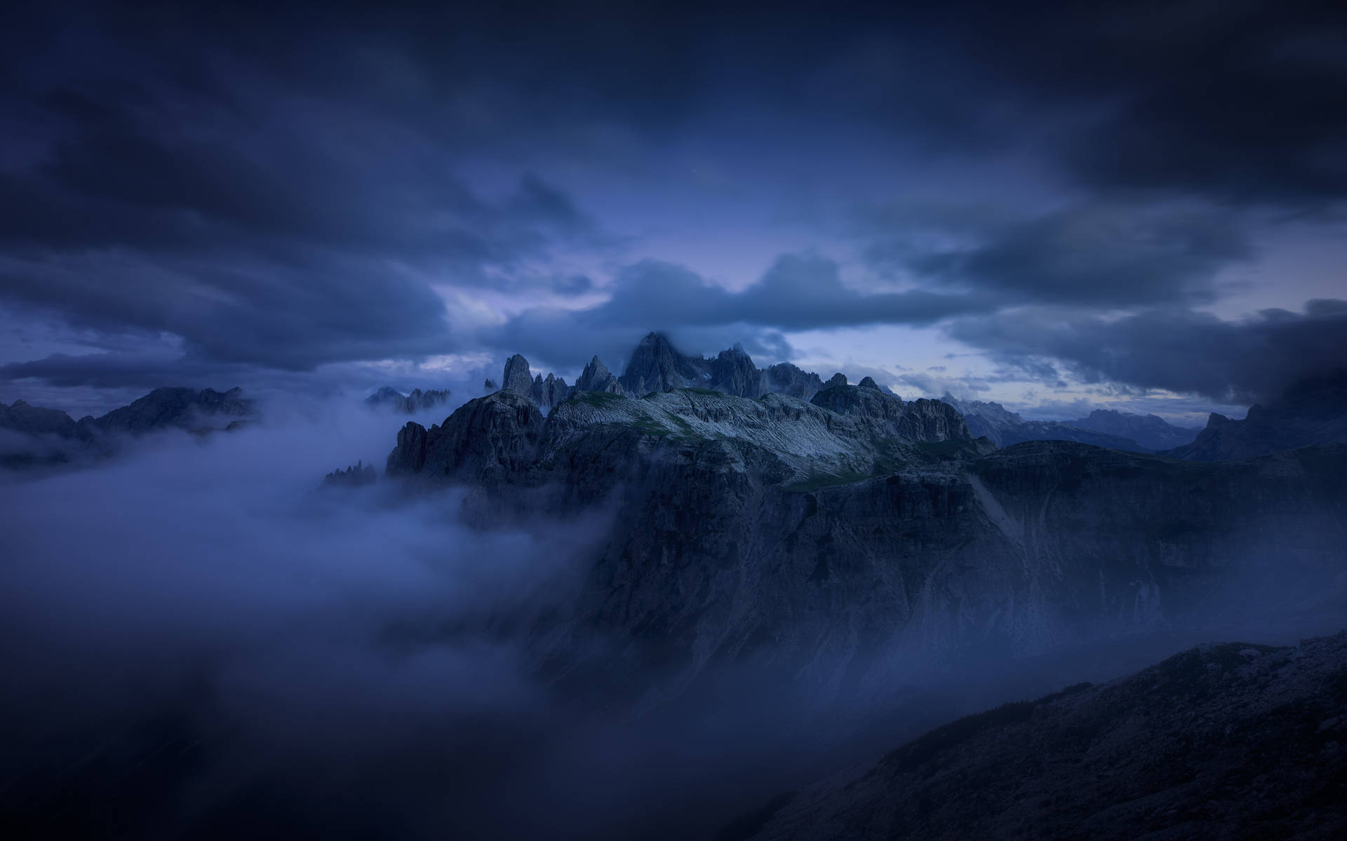 Dark Blue Clouds Hanging Over Mountains Wallpaper