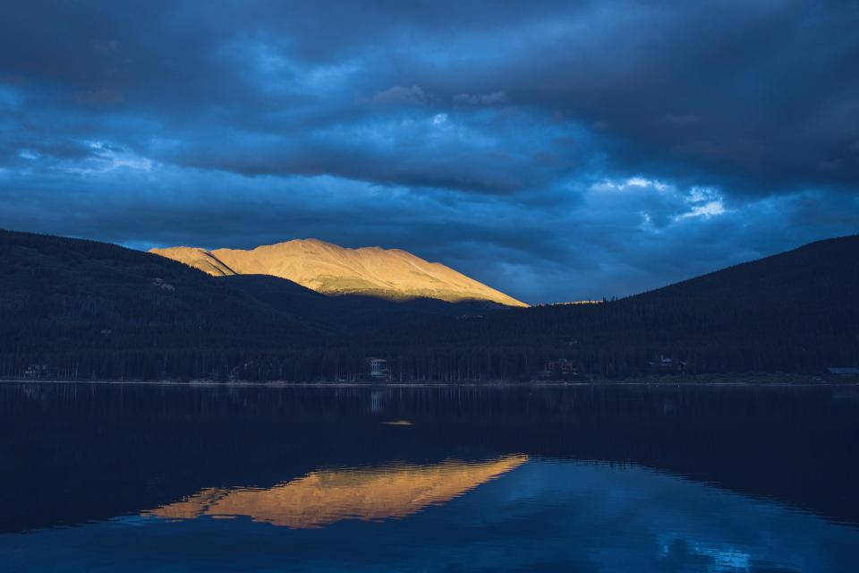 Mørkeblå skyer over sø landskab Wallpaper