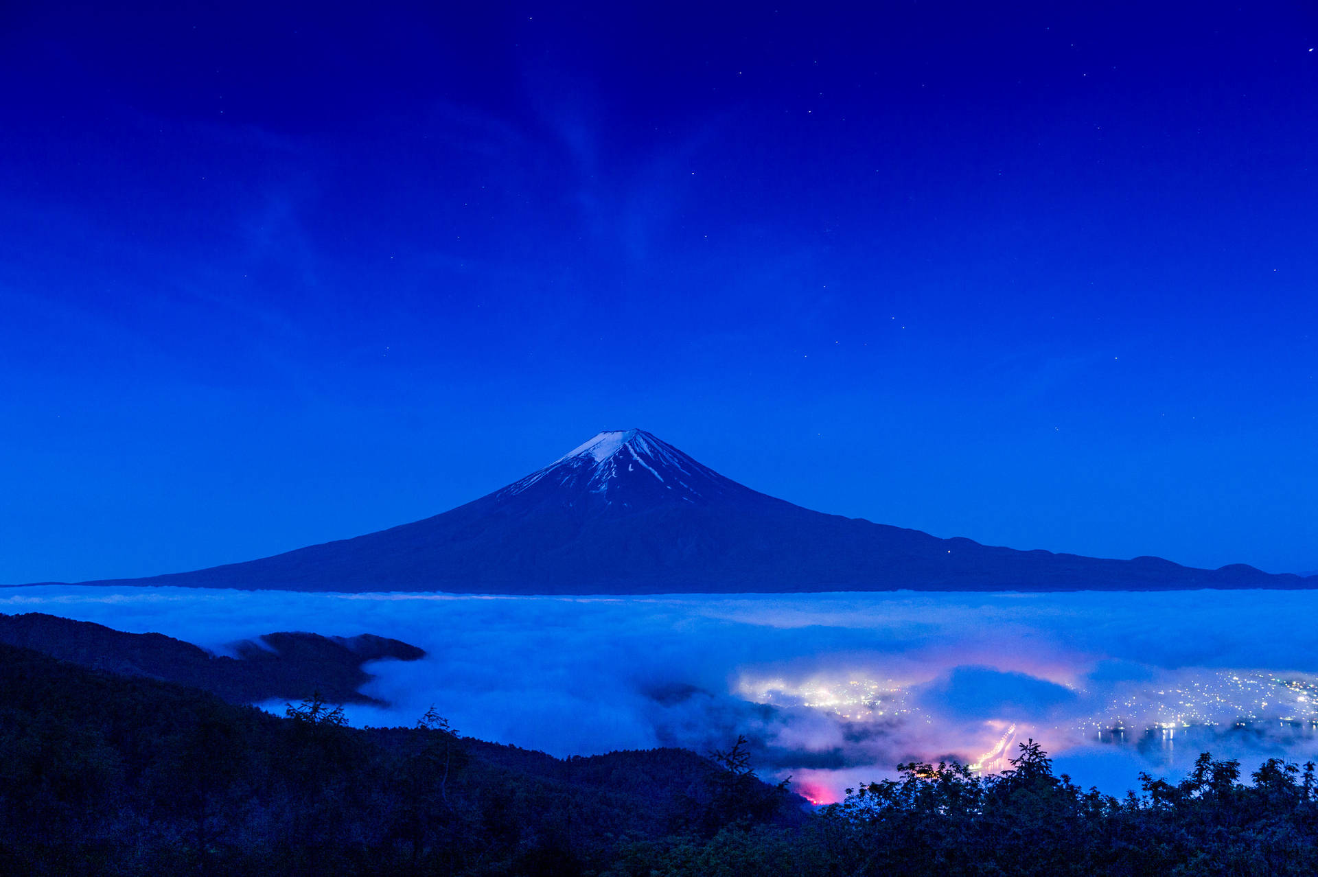 Mørkeblå Mount Fuji mod en stjernestrøms natte himmel. Wallpaper
