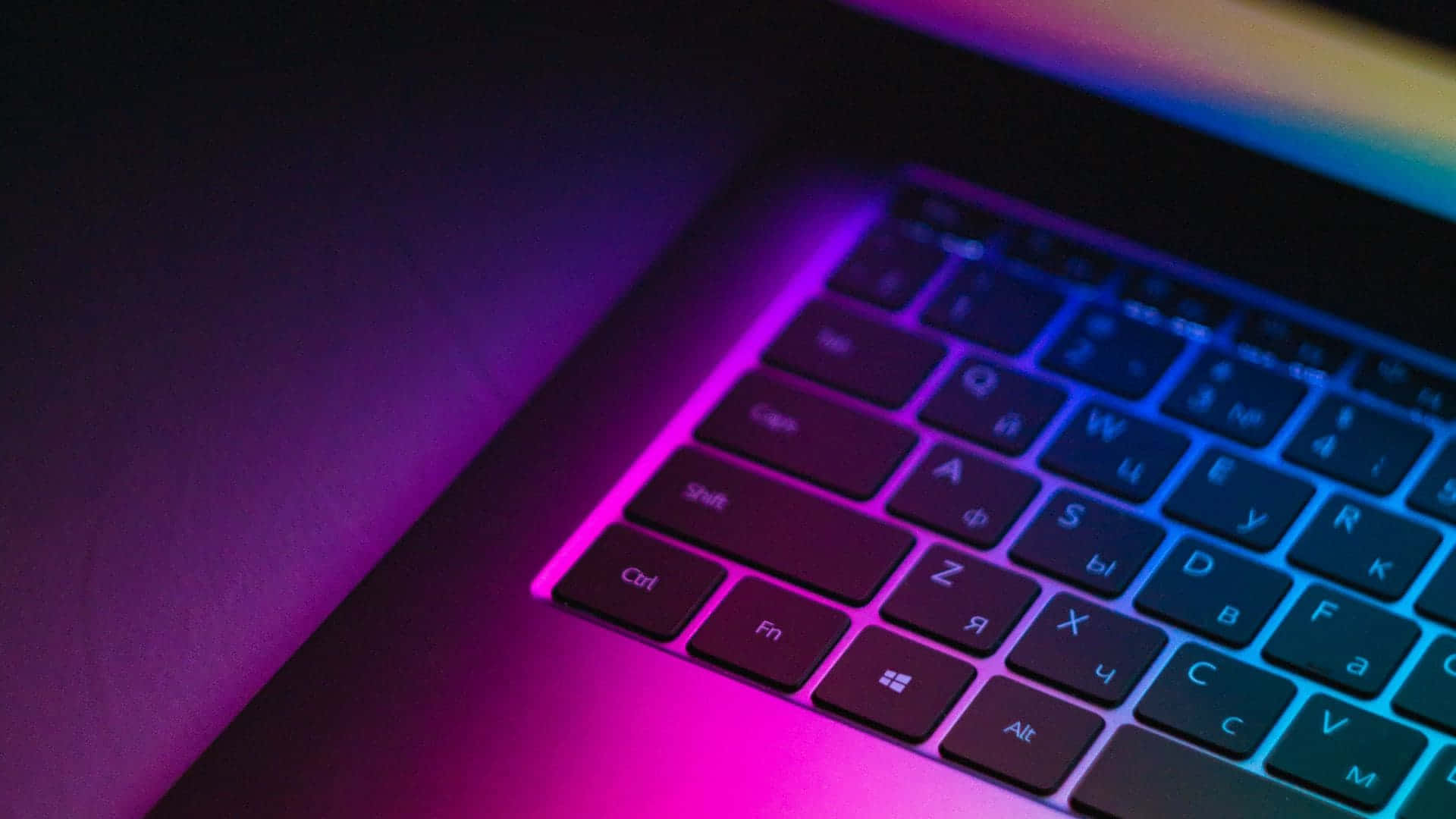 Et farverigt bærbart tastatur med en regnbue lys effekt. Wallpaper