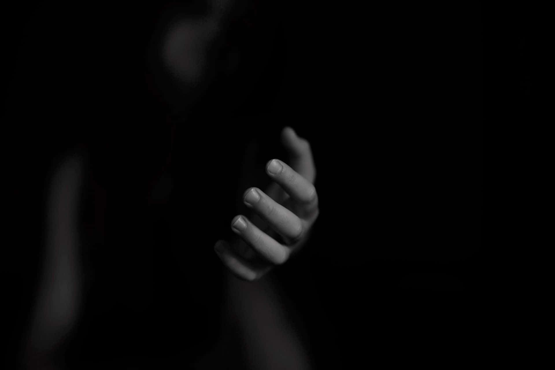 Mysterious Dark Hand reaching out in darkness Wallpaper
