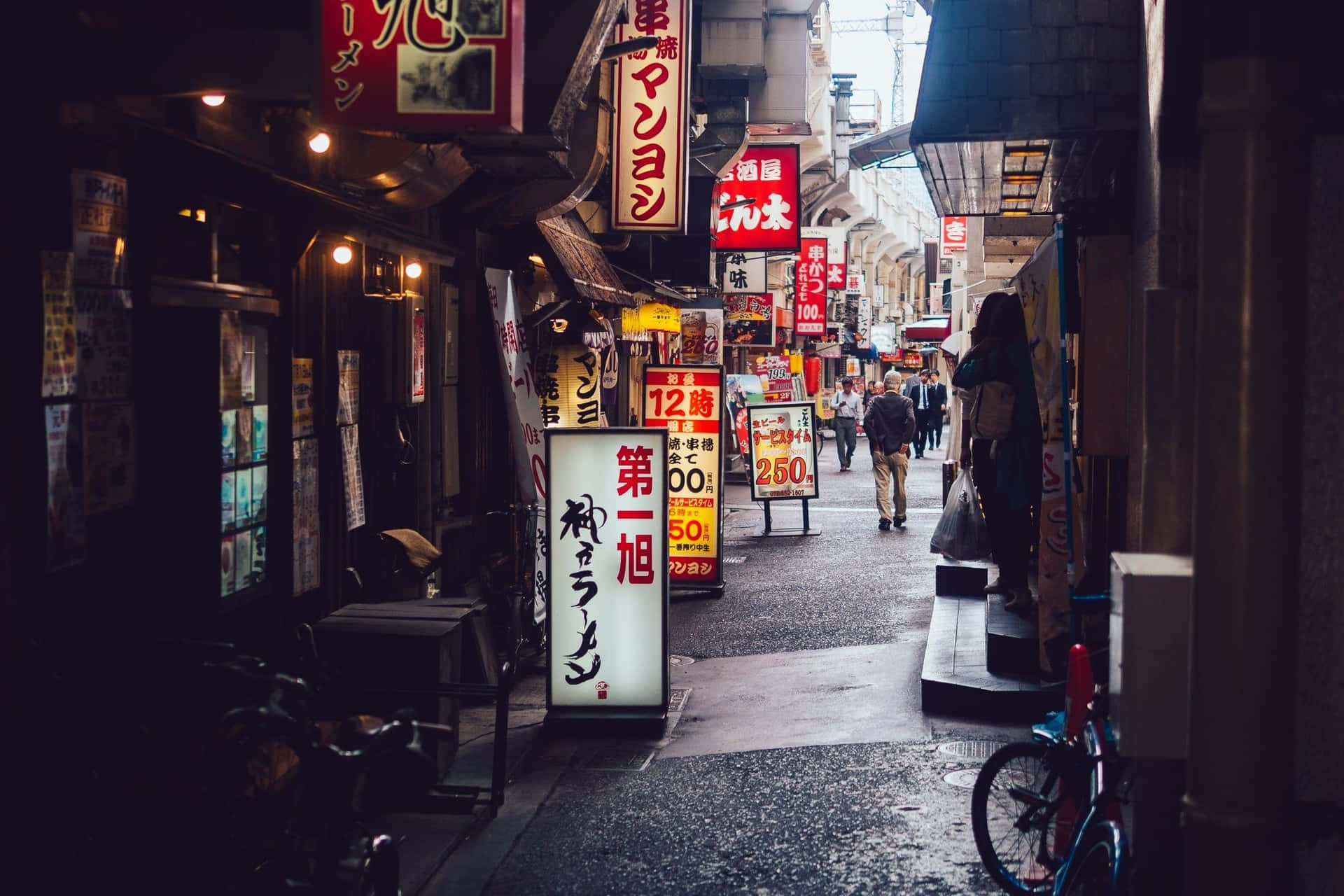 A Narrow Alleyway With A Lot Of Signs Wallpaper