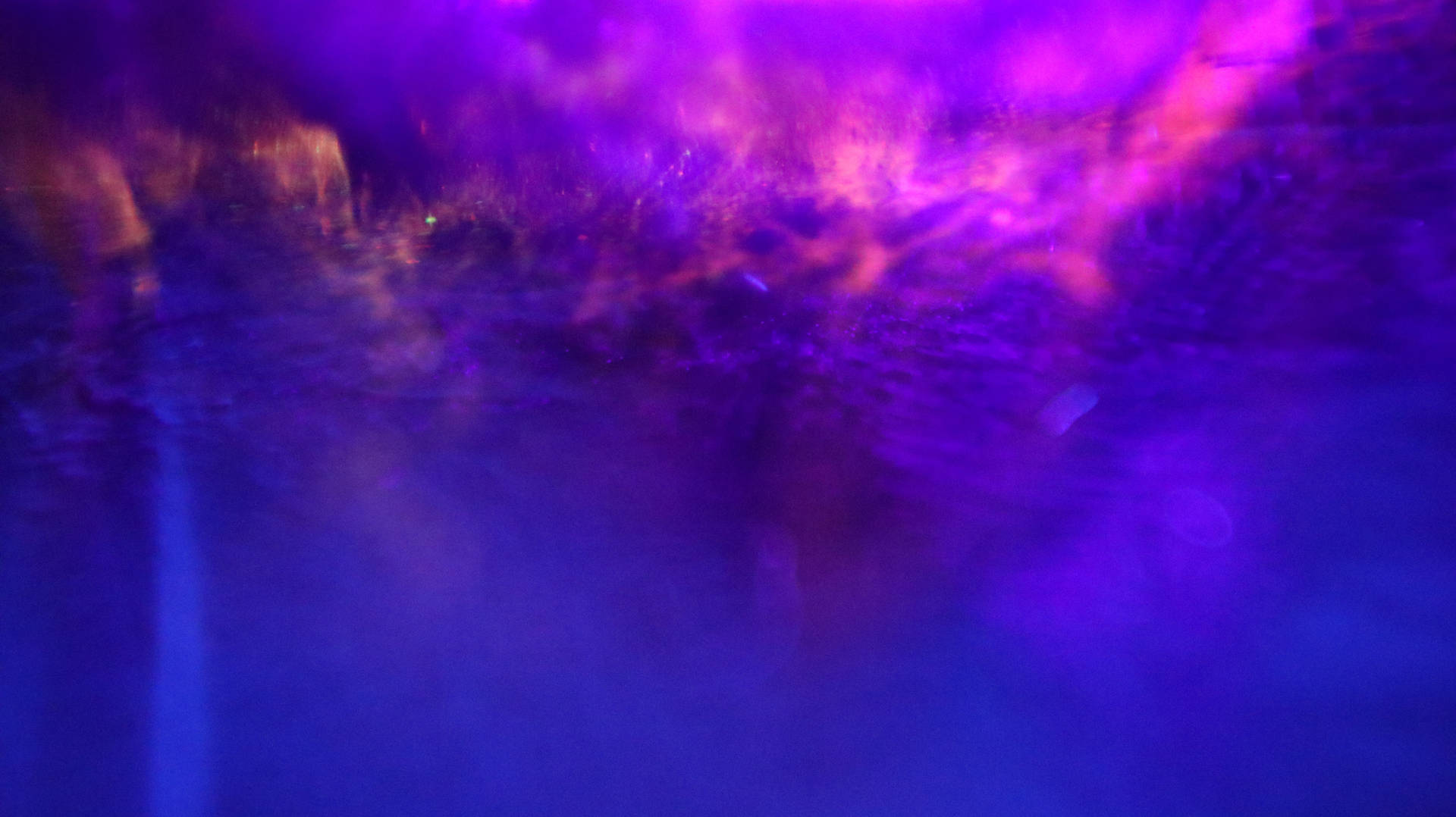 A Purple Light Is Shining On A Water Fountain Wallpaper