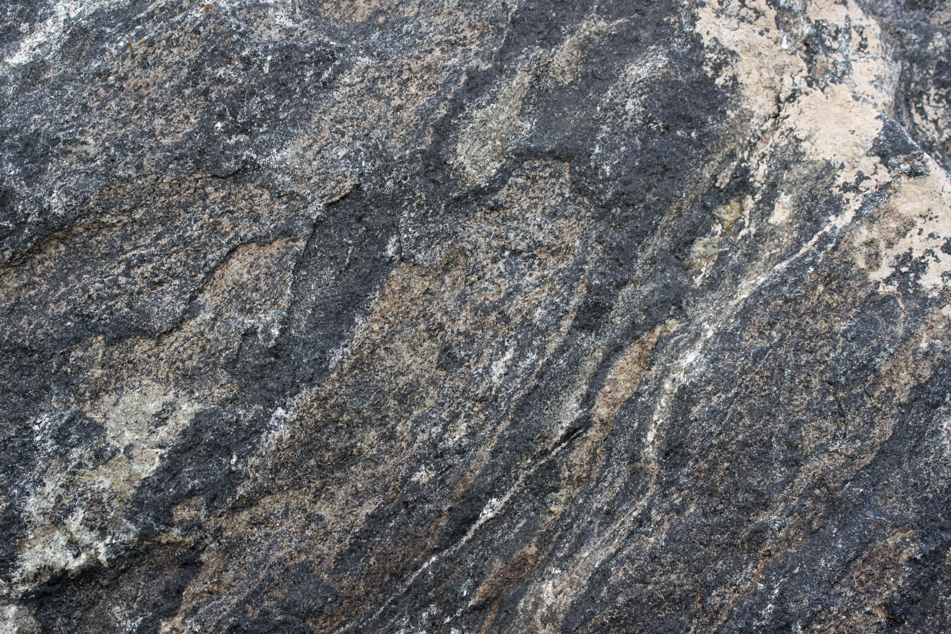 Enigmatic Dark Rock Formation on a Rugged Terrain Wallpaper