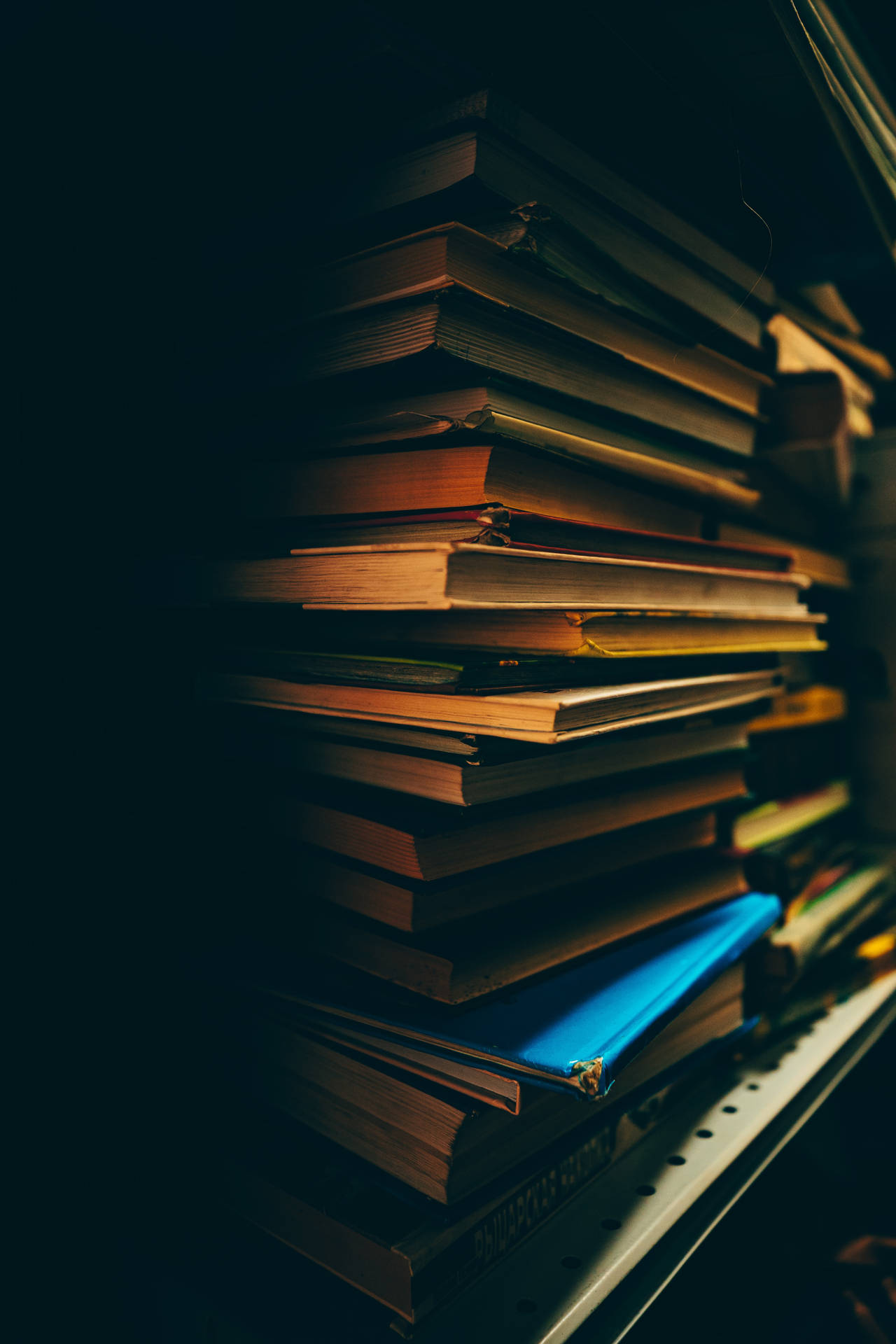 Dark shelf full of books on a stack wallpaper