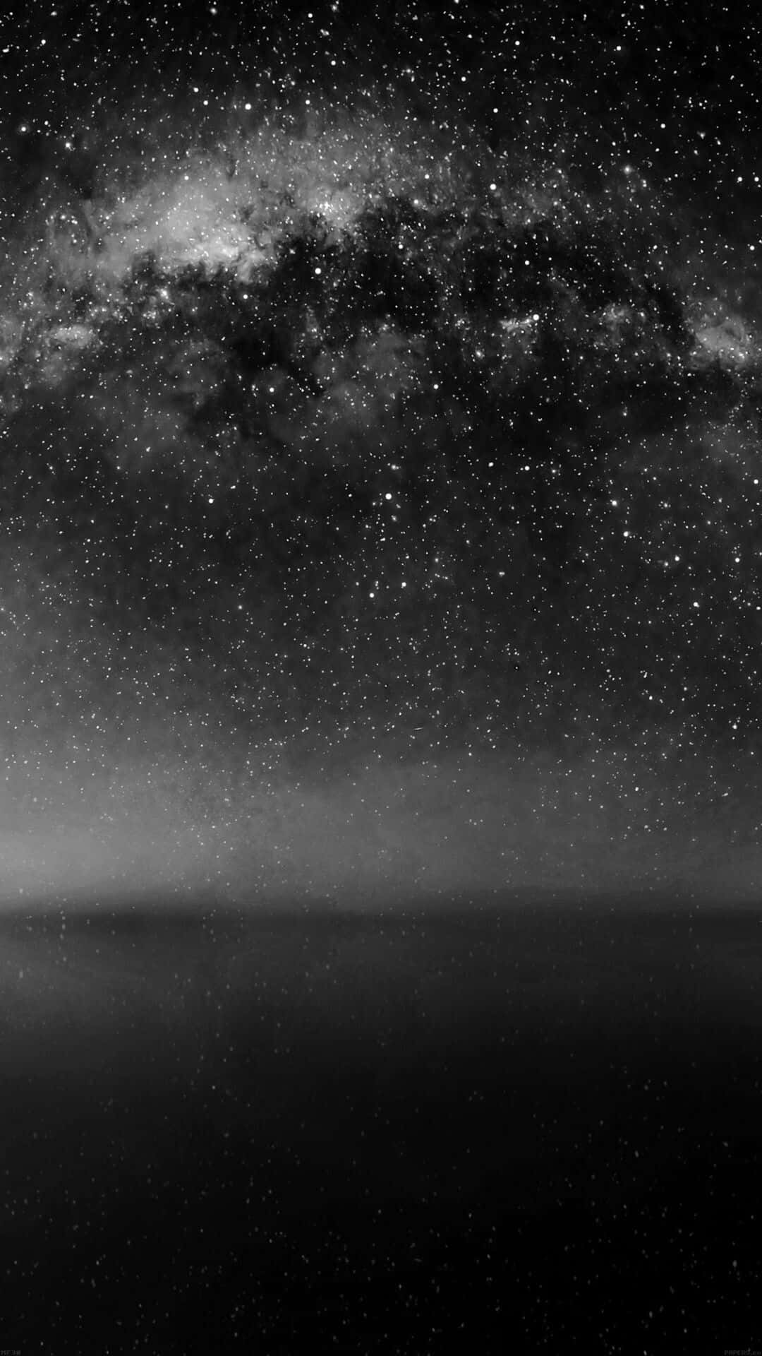 Mesmerizing Night Sky under Galactic Clouds Wallpaper