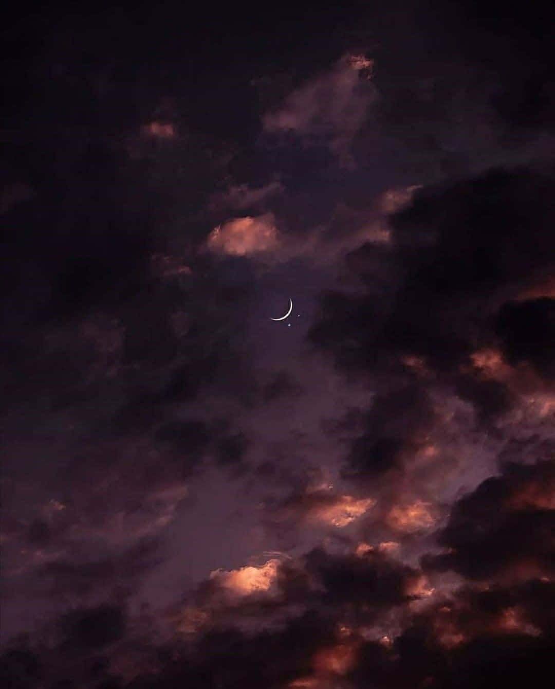 a crescent is seen in the sky with clouds