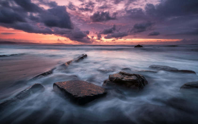 a beautiful sunset with rocks and water