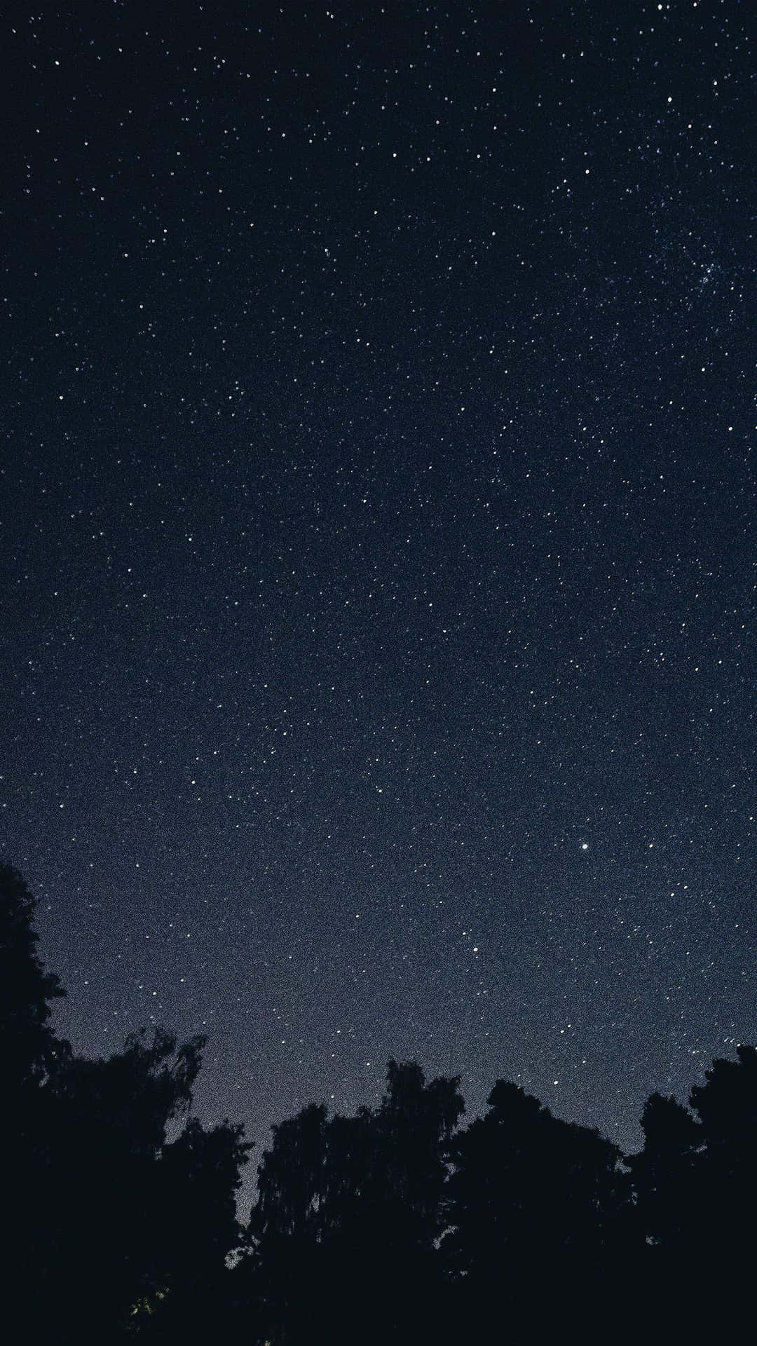 A dark starry night sky with stars illuminated in the night sky. Wallpaper