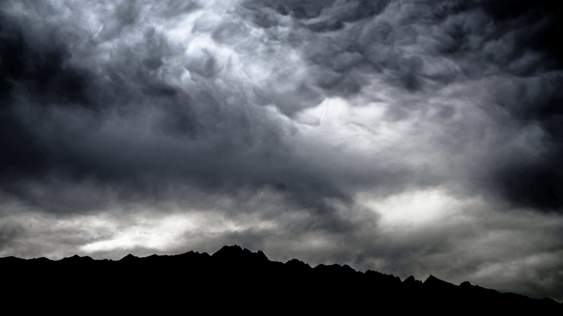 Dramatic Dark Storm Unleashing its Fury Over a Landscape Wallpaper