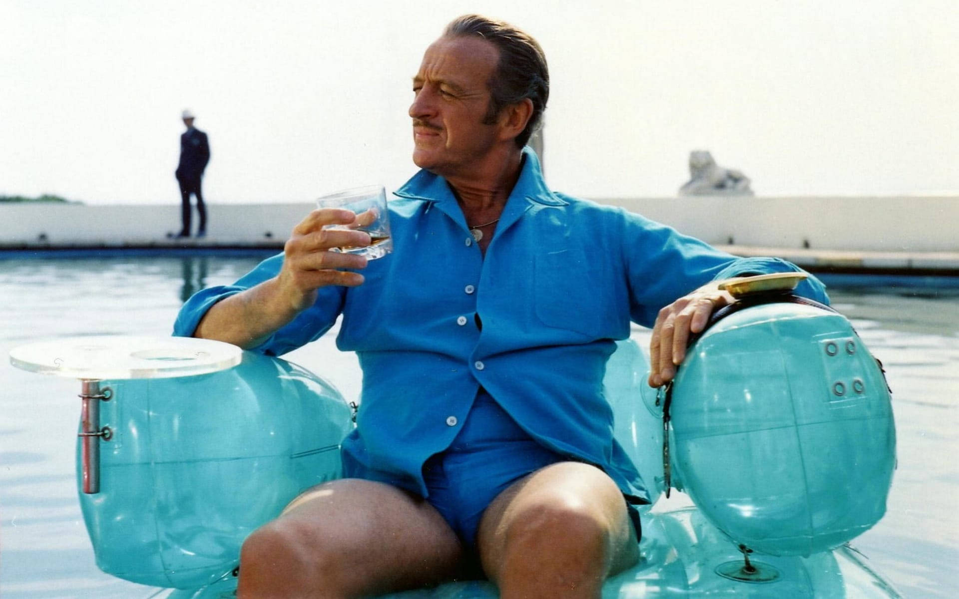 David Niven Holding Glass And Sitting Wallpaper