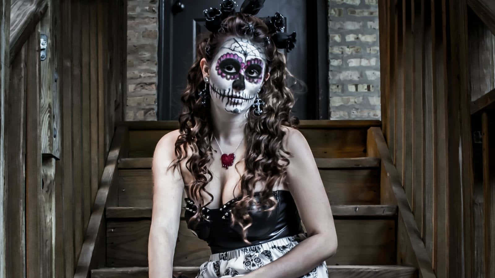 A Woman In A Sugar Skull Costume Sitting On Stairs