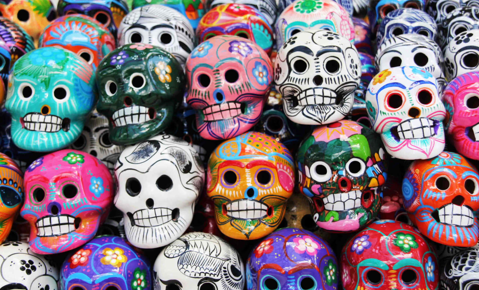 Colorful Sugar Skulls Are Arranged In Rows