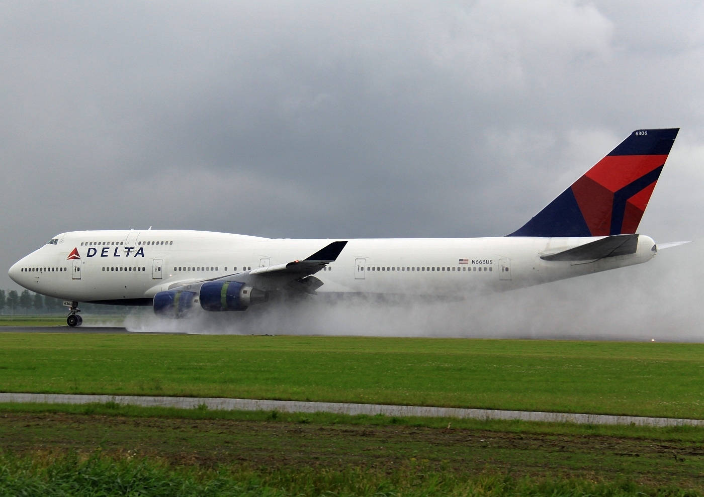 Delta Airlines flyrøg på græsmark. Wallpaper