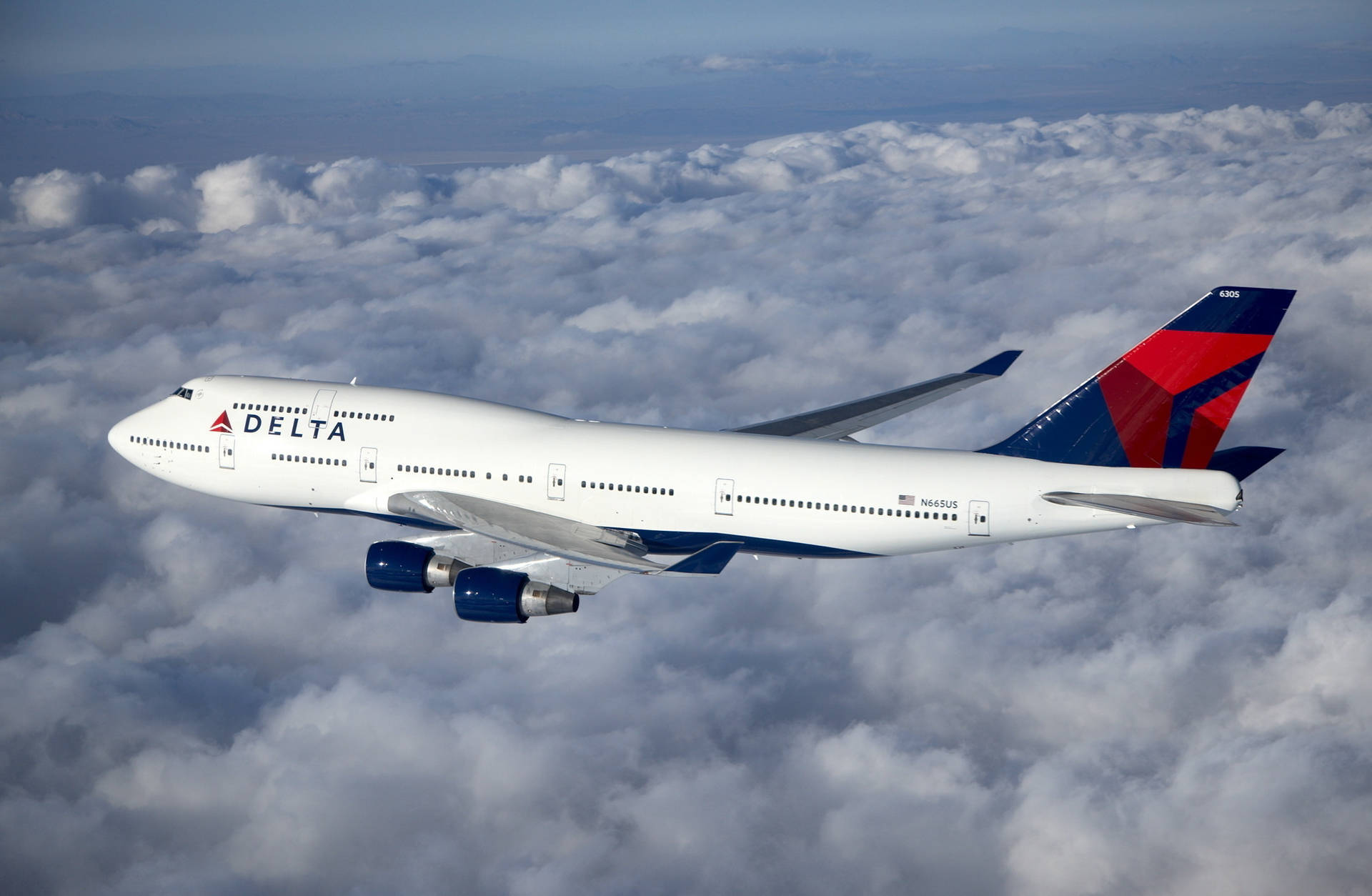 Delta Airlines Plane On Sea Of Gray Clouds Background